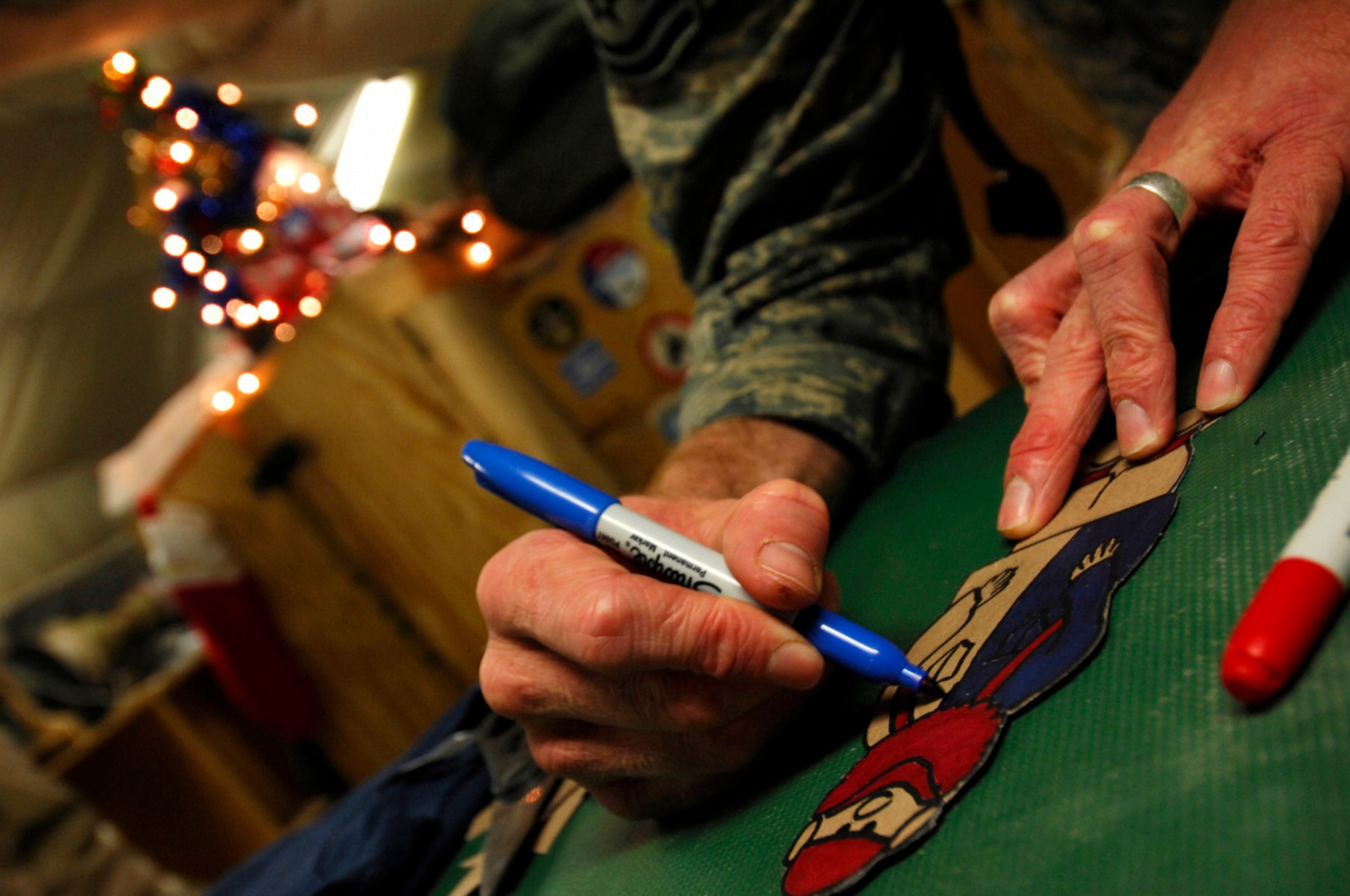 BAGRAM AIR BASE, Afghanistan - Tech. Sgt. Ryan McMaster, an aircrew life support technician with the 774th Expeditionary Airlift Squadron here, colors cartoon characters for a holiday diorama he created from locally-procured materials, Dec. 14, 2007. (U.S. Air Force photo/Staff Sgt. Joshua T Jasper)
