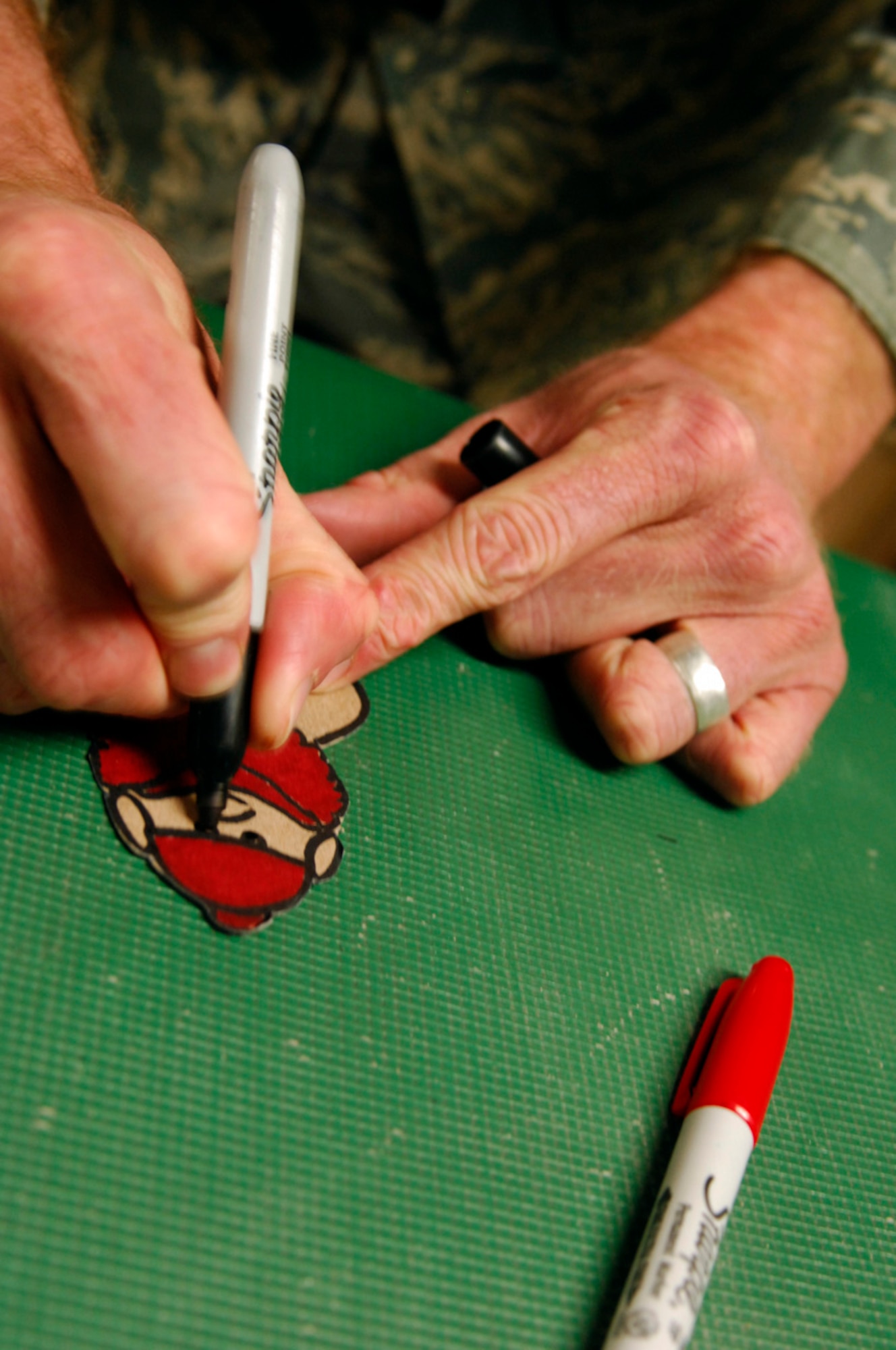 BAGRAM AIR BASE, Afghanistan - Tech. Sgt. Ryan McMaster, an aircrew life support technician with the 774th Expeditionary Airlift Squadron here, colors cartoon characters for a holiday diorama he created from locally-procured materials, Dec. 14, 2007. (U.S. Air Force photo/Staff Sgt. Joshua T Jasper)
