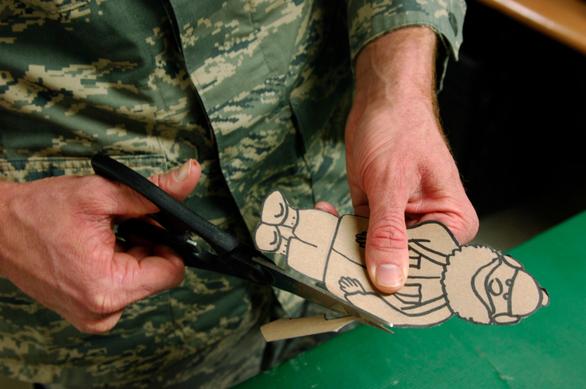 BAGRAM AIR BASE, Afghanistan - Tech. Sgt. Ryan McMaster, an aircrew life support technician with the 774th Expeditionary Airlift Squadron here, cuts out cartoon characters for a holiday diorama he created from locally-procured materials, Dec. 14, 2007.  (U.S. Air Force photo/Staff Sgt. Joshua T Jasper)
