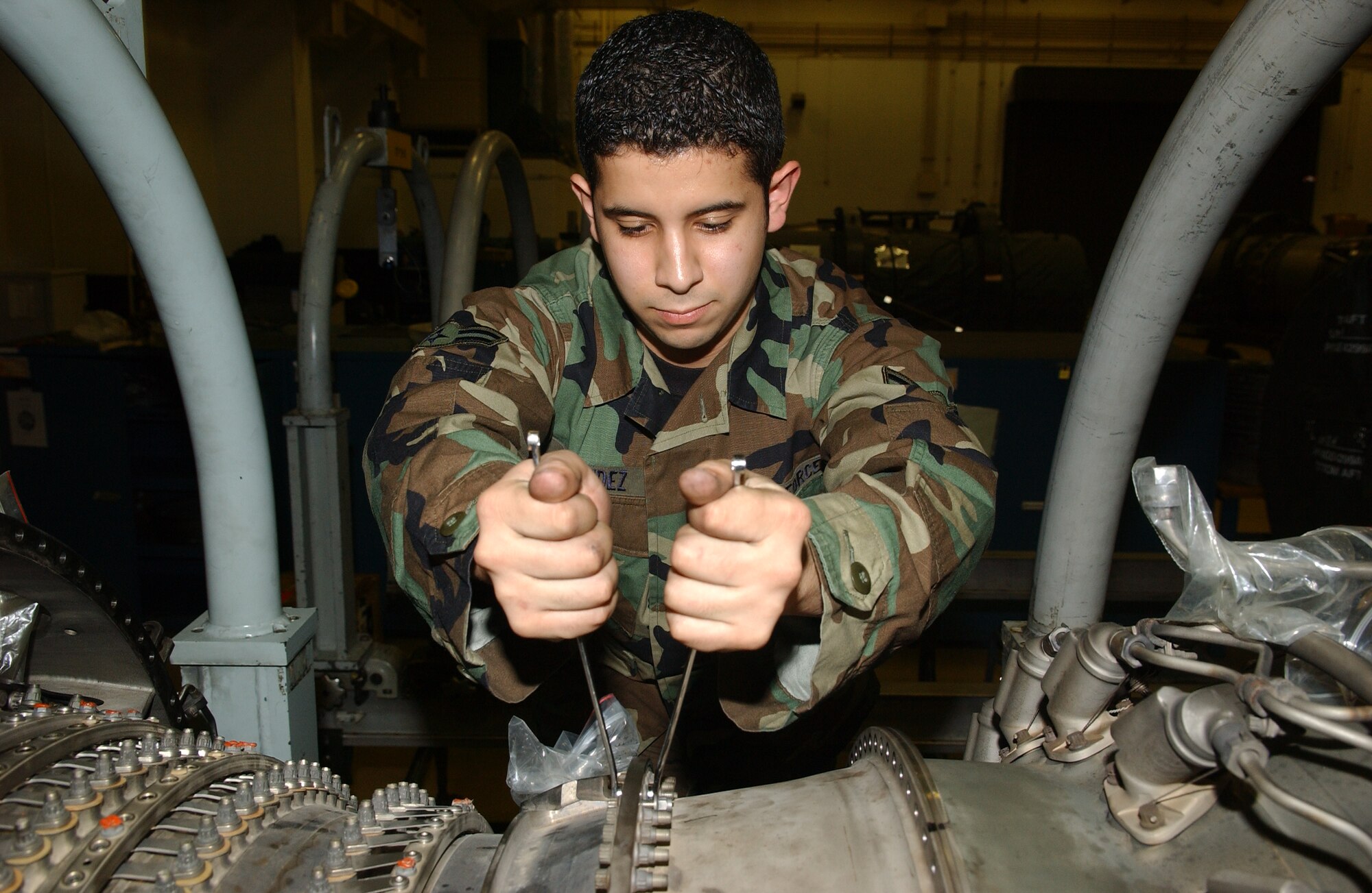 071214-F-0108B-001 MISAWA AIR BASE, Japan -- Airman 1st Class Jonathan Mendez, 35th Maintenance Squadron, tightens nuts and bolts on an F-16 jet engine.  Airman Mendez is a crew chief for the propulsion flight, known as the Queen Bee, and fixes F-16 engines for Misawa, Osan and Kunsan Air Base.
(U.S. Air Force photo by Senior Airman Robert Barnett)