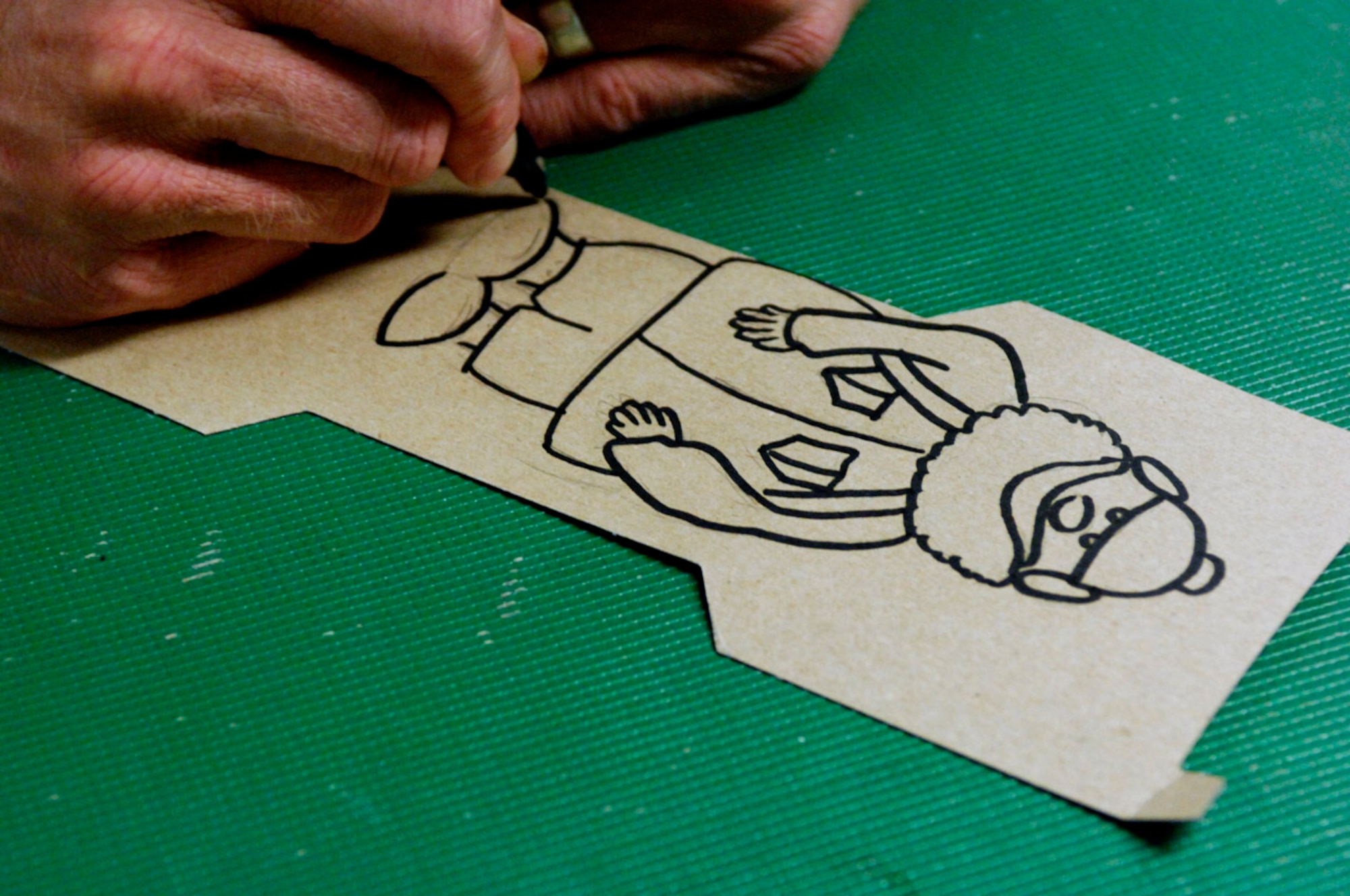 BAGRAM AIR BASE, Afghanistan - Tech. Sgt. Ryan McMaster, an aircrew life support technician with the 774th Expeditionary Airlift Squadron here, draws cartoon characters for a holiday diorama he created from locally-procured materials, Dec. 14, 2007. (U.S. Air Force photo/Staff Sgt. Joshua T Jasper)
