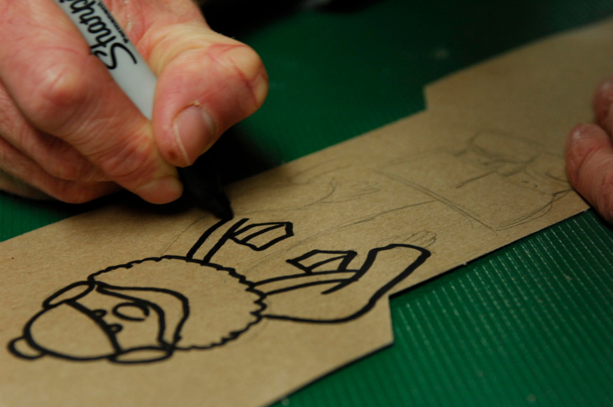 BAGRAM AIR BASE, Afghanistan - Tech. Sgt. Ryan McMaster, an aircrew life support technician with the 774th Expeditionary Airlift Squadron here, draws cartoon characters for a holiday diorama he created from locally-procured materials, Dec. 14, 2007.  (U.S. Air Force photo/Staff Sgt. Joshua T Jasper)