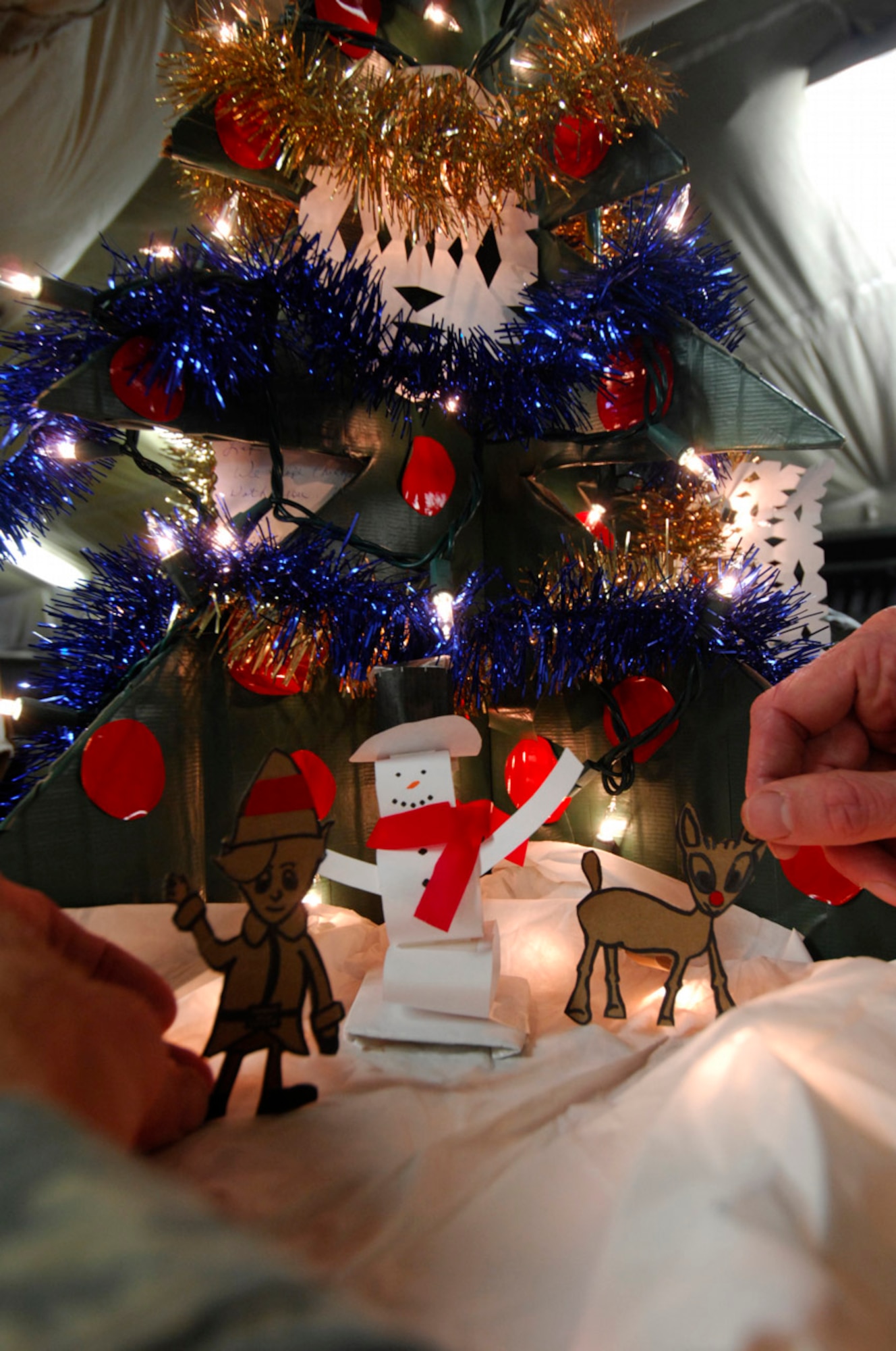 BAGRAM AIR BASE, Afghanistan - Tech. Sgt. Ryan McMaster, an aircrew life support technician with the 774th Expeditionary Airlift Squadron here, places figures for a holiday diorama next to a tree that he created with locally-procured materials, Dec. 14, 2007.   (U.S. Air Force photo/Staff Sgt. Joshua T Jasper)