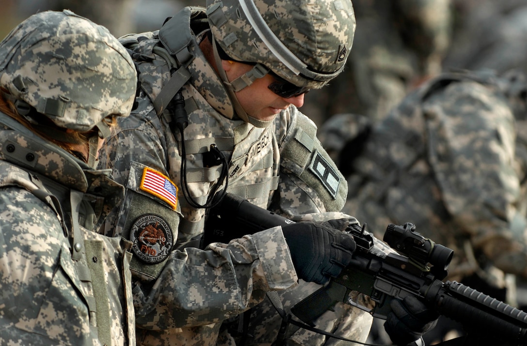 A First Army trainer assists an Indiana Army National Guard Soldier of 76th Infantry Brigade Combat Team during zeroing of weapons at Camp Atterbury Joint Maneuver Training center as part of their mobilization training prior to a scheduled deployment to Iraq, Dec. 14, 2007.