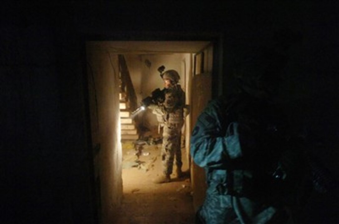 U.S. Army soldiers from Delta Company, 1st Battalion, 168th Infantry Regiment search an abandoned building for weapons caches during a night operation in the Al Furat section of Baghdad, Iraq, on Dec. 12, 2007.  