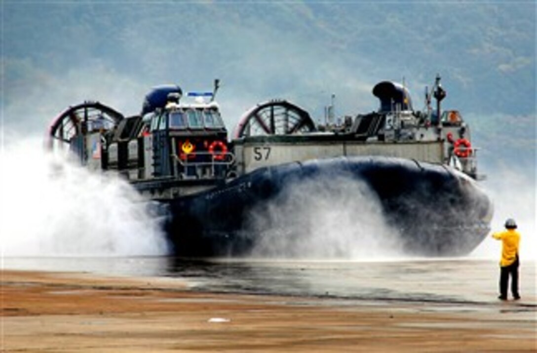 Navy Petty Officer 3rd Class William Jordan, assigned to Assault Craft Unit  5, directs a landing craft air cushion ashore after the unit's return to Sasebo, Japan, following a fall patrol aboard the USS Essex, Dec. 11, 2007.