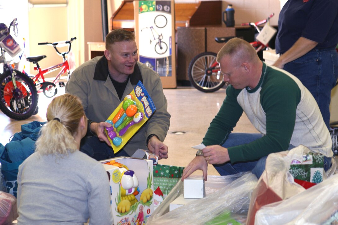 Gunnery Sgt. Jamie Lybrand (left), a military police staff noncommissioned officer-in-charge with Special Operations Training Group, II Marine Expeditionary Force, and Staff Sgt. Jeremy Gohl, a military police officer also with SOTG, help members of the Salvation Army Church sort toys for needy families here Dec. 18. Five Marines and a sailor volunteered to assist the program through the coordination of Petty Officer 1st Class Chelboni Singleton, a religious program specialist with II Marine Expeditionary Force Headquarters Group, II MEF.