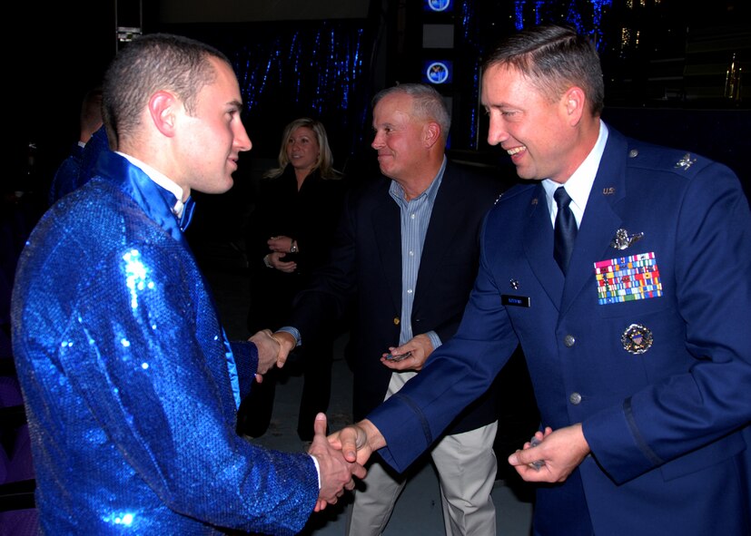 OSAN AIR BASE, Republic of Korea -- Lt Gen Stephen Wood, Commander, Seventh Air Force (center) and Col Jon Norman, Commander, 51st Fighter Wing (right), present their commander's coins to U. S. Air Force Tops in Blue members after their performance for Team Osan members during their annual world tour celebrating "The Fly-By", a musical tribute to 60 years of proud Air Force history.  (U. S. Air Force photo by Senior Master Sgt. Marvin Krause)