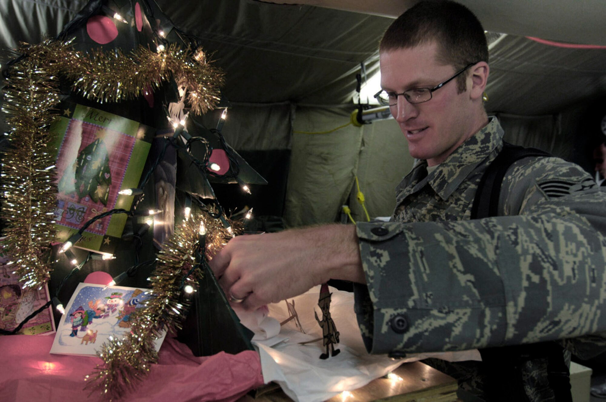 Tech. Sgt. Ryan McMaster places figures for a holiday diorama next to a tree that he created with locally-procured materials Dec. 14 at Bagram Air Base, Afghanistan. Sergeant McMaster is an aircrew life support technician with the 774th Expeditionary Airlift Squadron. (U.S. Air Force photo/Staff Sgt. Joshua T. Jasper)