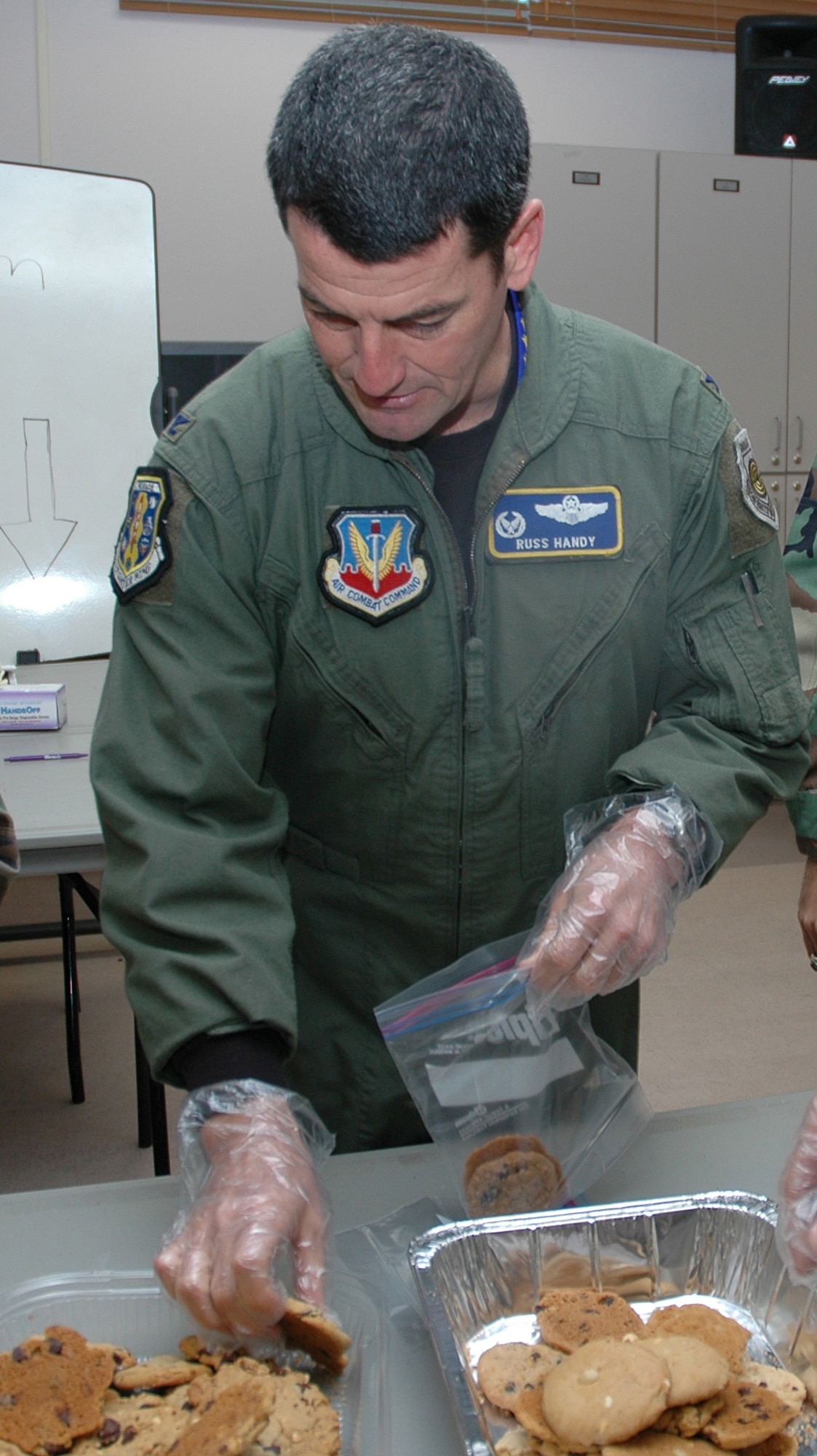 EGLIN AIR FORCE BASE, Fla. -- Col. Russell Handy, 33rd Fighter Wing commander, assists volunteers in bagging cookie donations for the Team Eglin Cookie Caper 2007 event Dec. 17. The Cookie Caper goal was to collect 1,001 dozen cookies for the event. They exceeded their expectations and handed out 1,633 dozen or 19,596 cookies to Airmen. (U.S. Air Force photo by Staff Sgt. LuCelia Ball)