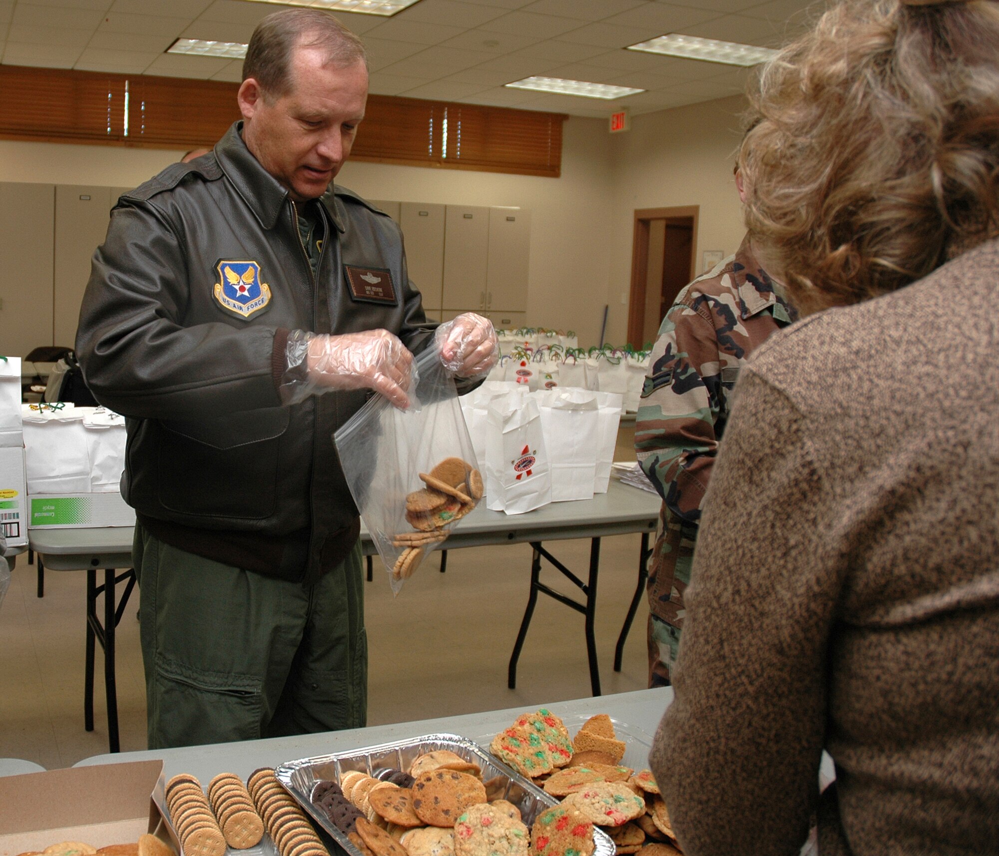 EGLIN AIR FORCE BASE, Fla. -- Maj. Gen. David Eidsaune, Program Executive Officer for Weapons and Air Armament Center commander, assists volunteers in bagging cookies Dec. 17 for the Team Eglin Cookie Caper 2007 event. The Cookie Caper goal was to collect 1,001 dozen cookies for the event. They exceeded their expectations and handed out 1,633 dozen, or 19,596 cookies, to Airmen. (U.S. Air Force photo by Staff Sgt. LuCelia Ball)