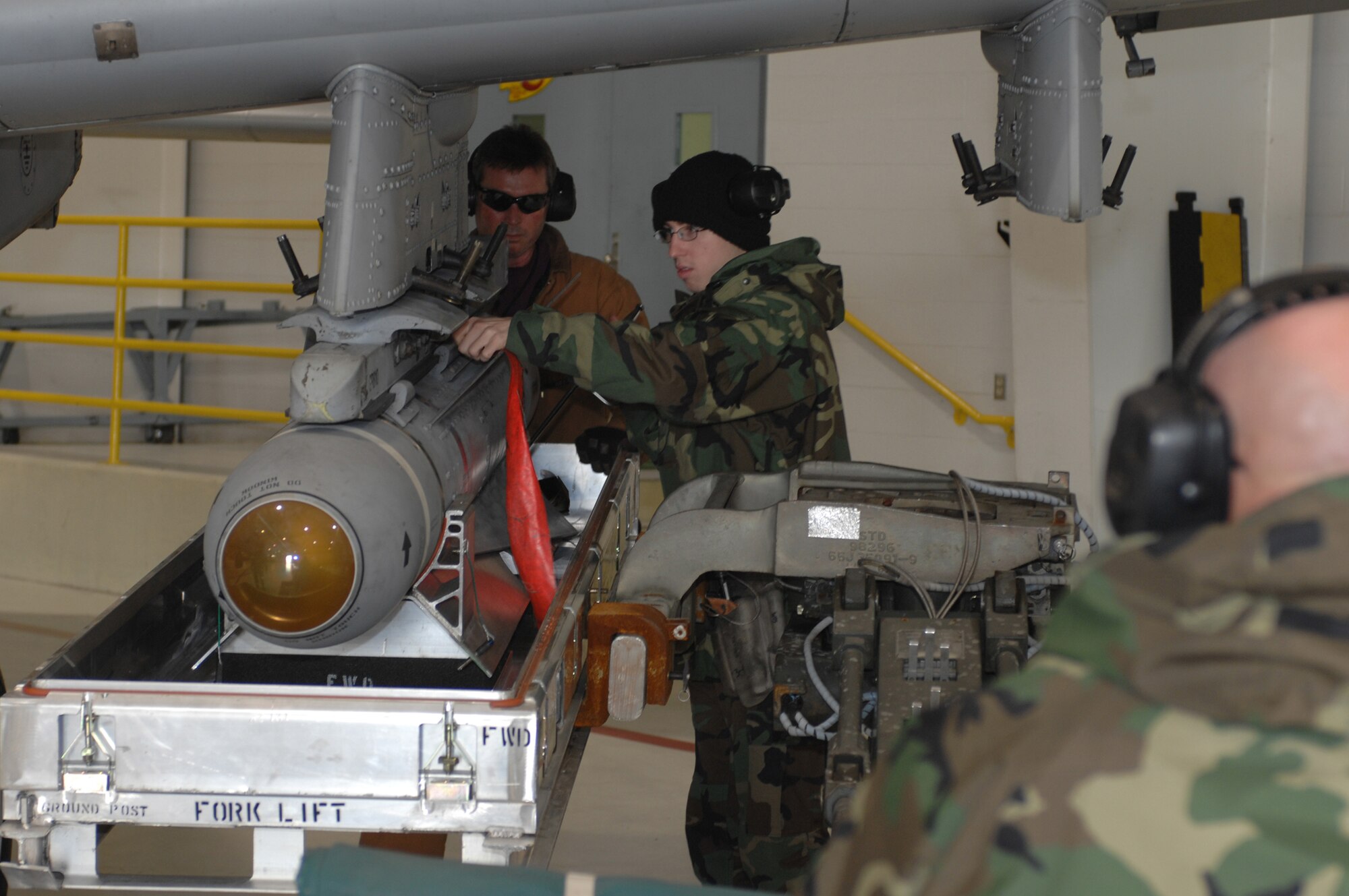 WHITEMAN AIR FORCE BASE, Mo. -- Airman 1st Class Shane Dunn and Master Sgt. Jim Kirksey, 442nd Aircraft Maintenance Squadron, pull the pin to release the TGM 65 Maverick missile onto a jammer controlled by Tech. Sgt. Ken Portell, 442nd Aircraft Maintenance Squadron, Dec. 19. (U.S. Air Force photo/Tech. Sgt. Samuel A. Park) 