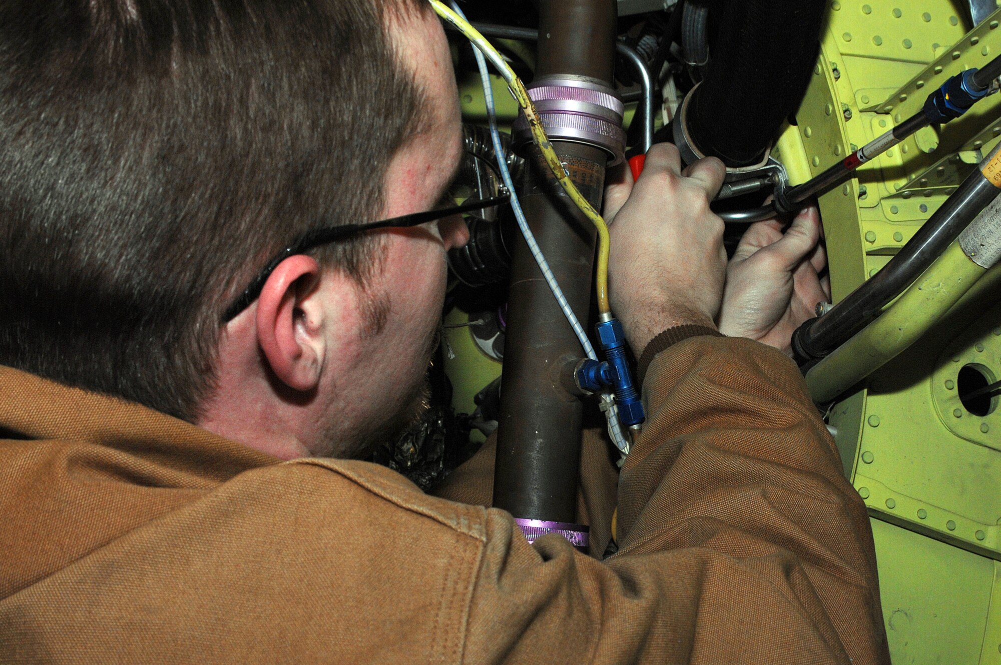 WHITEMAN AIR FORCE BASE, Mo. -- Senior Airman Brian Ryberg, 442nd Aircraft Maintenance Squadron, installs clamps on a lower engine hose Dec. 19. (U.S. Air Force photo/Tech. Sgt. Samuel A. Park)photo/Tech. Sgt. Samuel A. Park) 