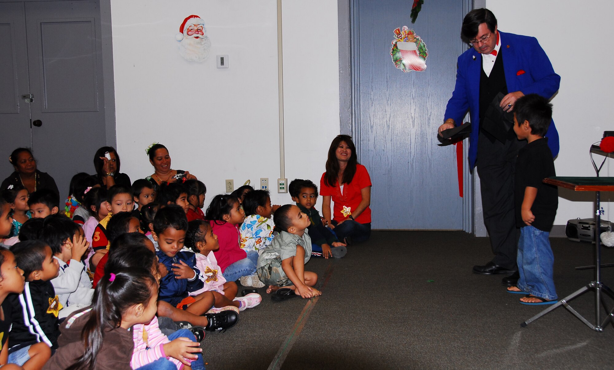 Mr. Glen Bailey, 15th Airlift Wing, performs a magic show for childern from the Head Start holiday party. The party featured a magic show, games, lunch and a visit from Santa. Photo by Ed Foster
