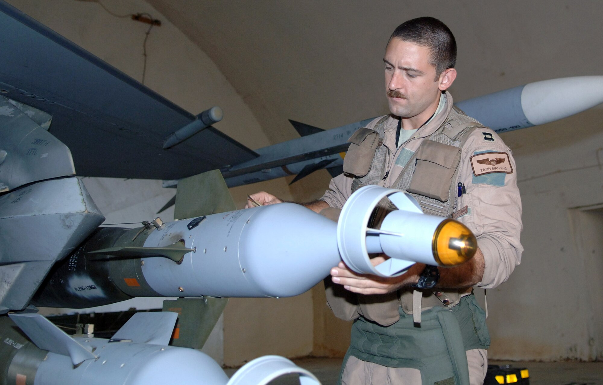 Capt. Zach Manning inspects a guided bomb unit during his pre-flight inspection at Balad Air Base, Iraq. Captain Manning, a 4th Expeditionary Fighter Squadron F-16 pilot, is deployed from Hill Air Force Base, Utah. (U.S. Air Force photo/Senior Airman Terri Barriere)