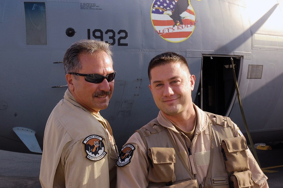 Senior Master Sgt. Michael Kovach (left) and his son, Master Sgt. Shawn Kovach, compare patches after the son received a patch for flying his 100th combat mission Nov. 19 in Southwest Asia. Both Airmen are assigned to the 43rd Expeditionary Electronic Combat Squadron and are deployed from the Pennsylvania Air National Guard's 193rd Special Operations Wing from Middletown, Penn. (U.S. Air Force photo/Staff Sgt. Tia Schroeder) 
