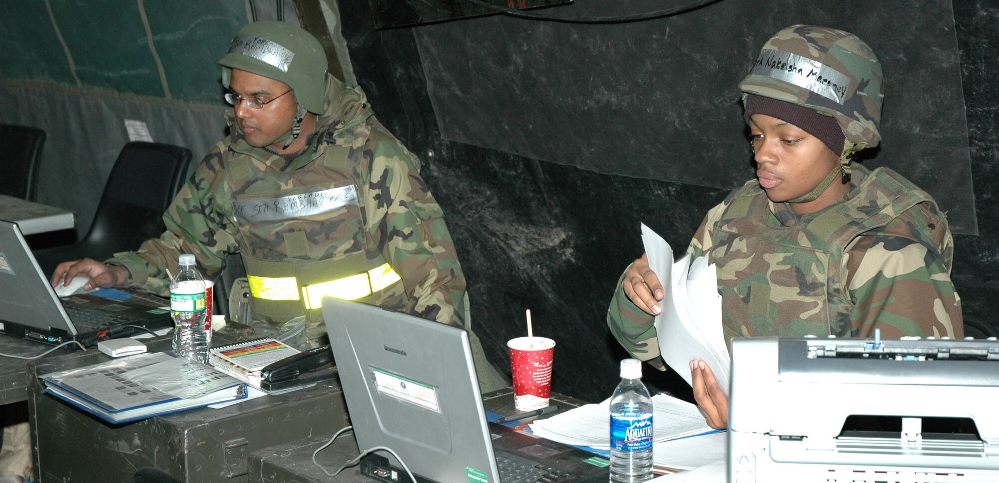 Senior Airman Yogendra Rambharose, 341st Comptroller Squadron travel technician, and Senior Airman NaKeisha Maroney, 341st CPTS service technician, provide financial customer support during an expeditionary readiness exercise at Camp Grizzly Dec. 13. (U.S. Air Force photo/Airman 1st Class Dillon White)  