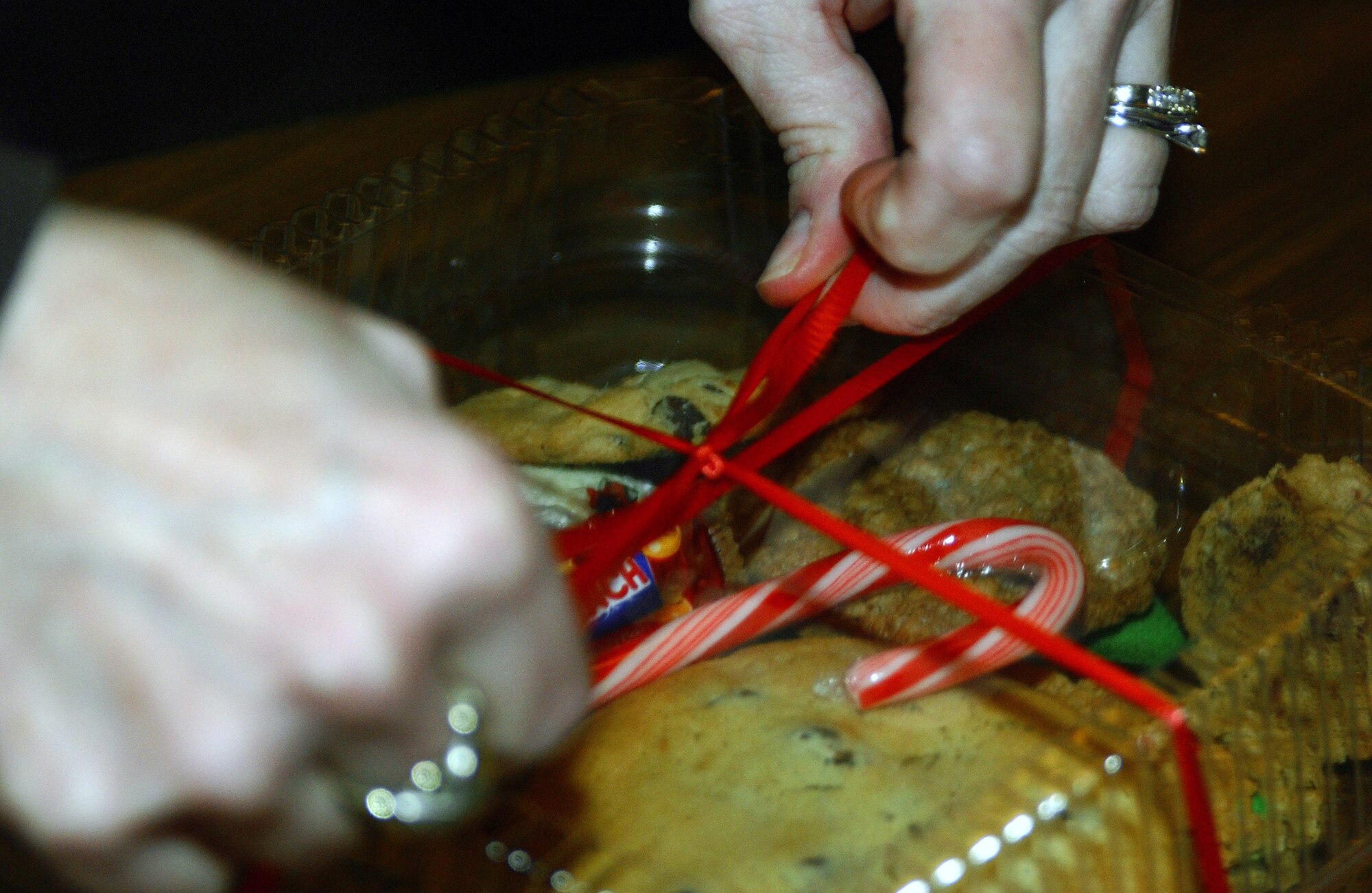 A box of homemade cookies gets the finishing touches put on it before being picked up for delivery during Operation Cookie Crunch Dec. 14 at Eielson Air Force Base, Alaska. The Eielson Officer's Spouses Club sponsors and organizes the yearly event. More than 550 homemade cookies are dropped off and packaged by volunteers and then delivered by squadron first sergeants to single Airmen living in the dormitories as a holiday gesture. (U.S. Air Force photo/Airman 1st Class Nora Anton) 