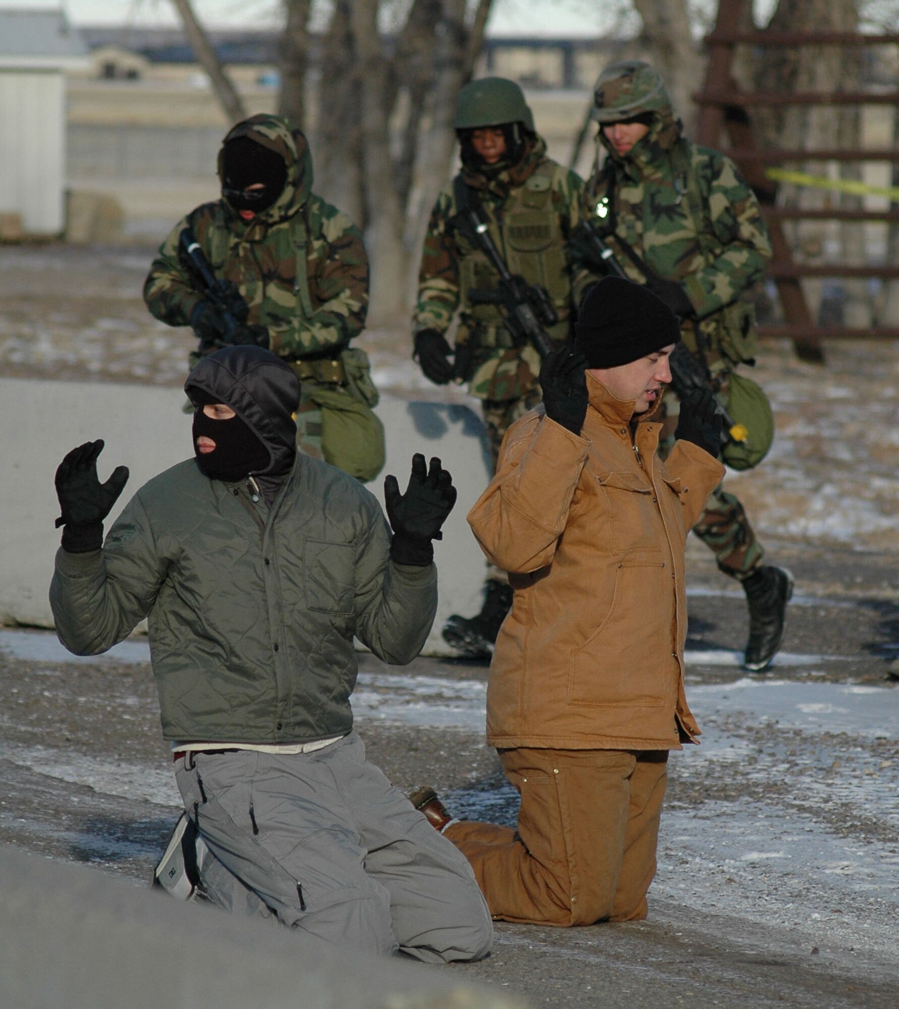Security forces Airmen apprehend role-player Airmen simulating non-violent foreign nationals attempting to enter the base during an expeditionary readiness exercise at Camp Grizzly Dec. 12. (U.S. Air Force photo/Airman 1st Class Dillon White)