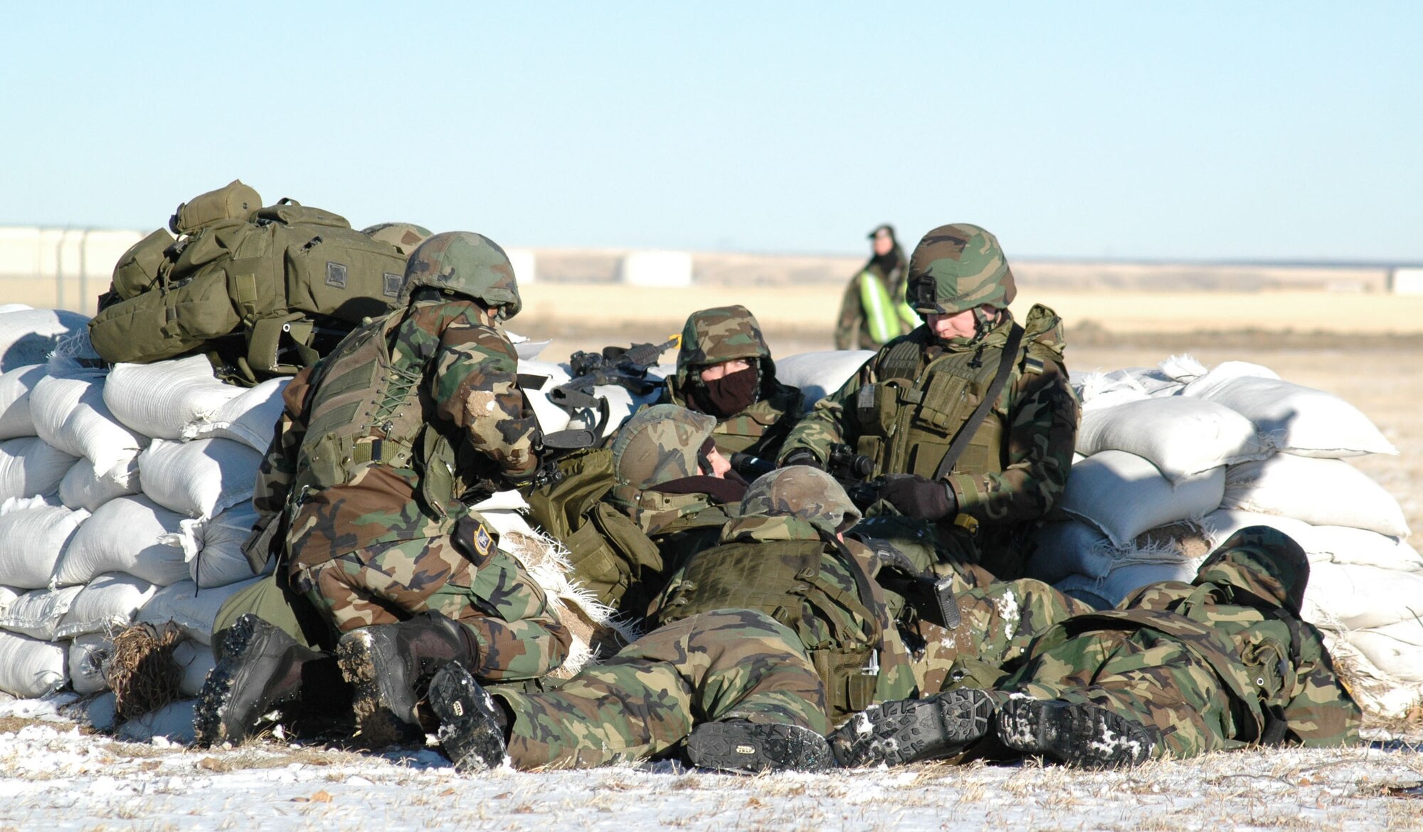 Airmen participating in an expeditionary readiness exercise go into Alarm Red behind a defensive fighting position during a simulated mortar attack at Camp Grizzly Dec. 12. (U.S. Air Force photo/Airman 1st Class Dillon White)