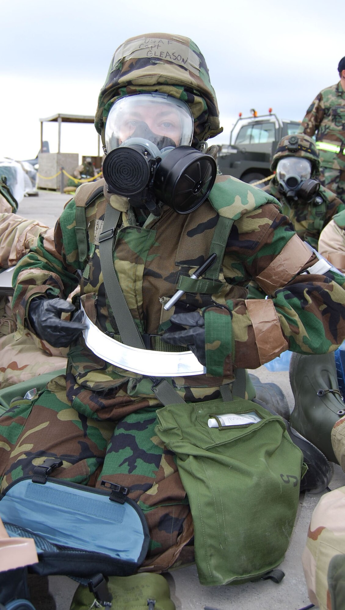 Capt. Carla Gleason, a 433rd Airlift Wing Public Affairs officer, takes shelter in a simulated bunker during the recent Wing Operational Readiness Inspection. Capt. Gleason is wearing her full Mission Oriented Protective Posture ensamble during a simulated attack. (U.S. Air Force Photo by Master Sgt. Collen McGee)
