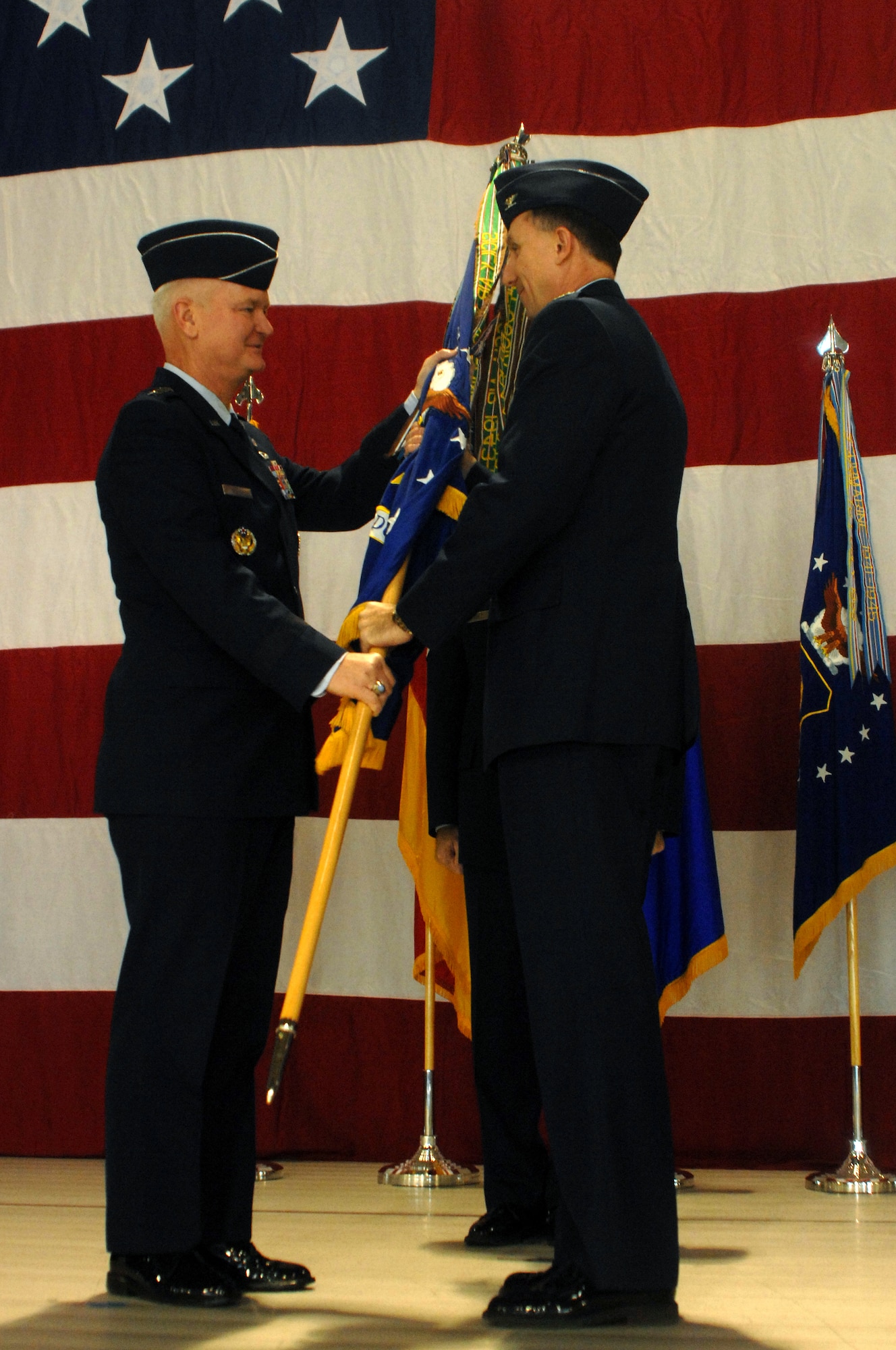 Col. Bill Bender accepts the 86th Airlift Wing flag from Lt. Gen. Rod Bishop, 3rd Air Force commander, at a change of command ceremony Dec. 19 in Ramstein's Hangar 1. (U.S. Air Force photo/Airman 1st Class Kenny Holston)