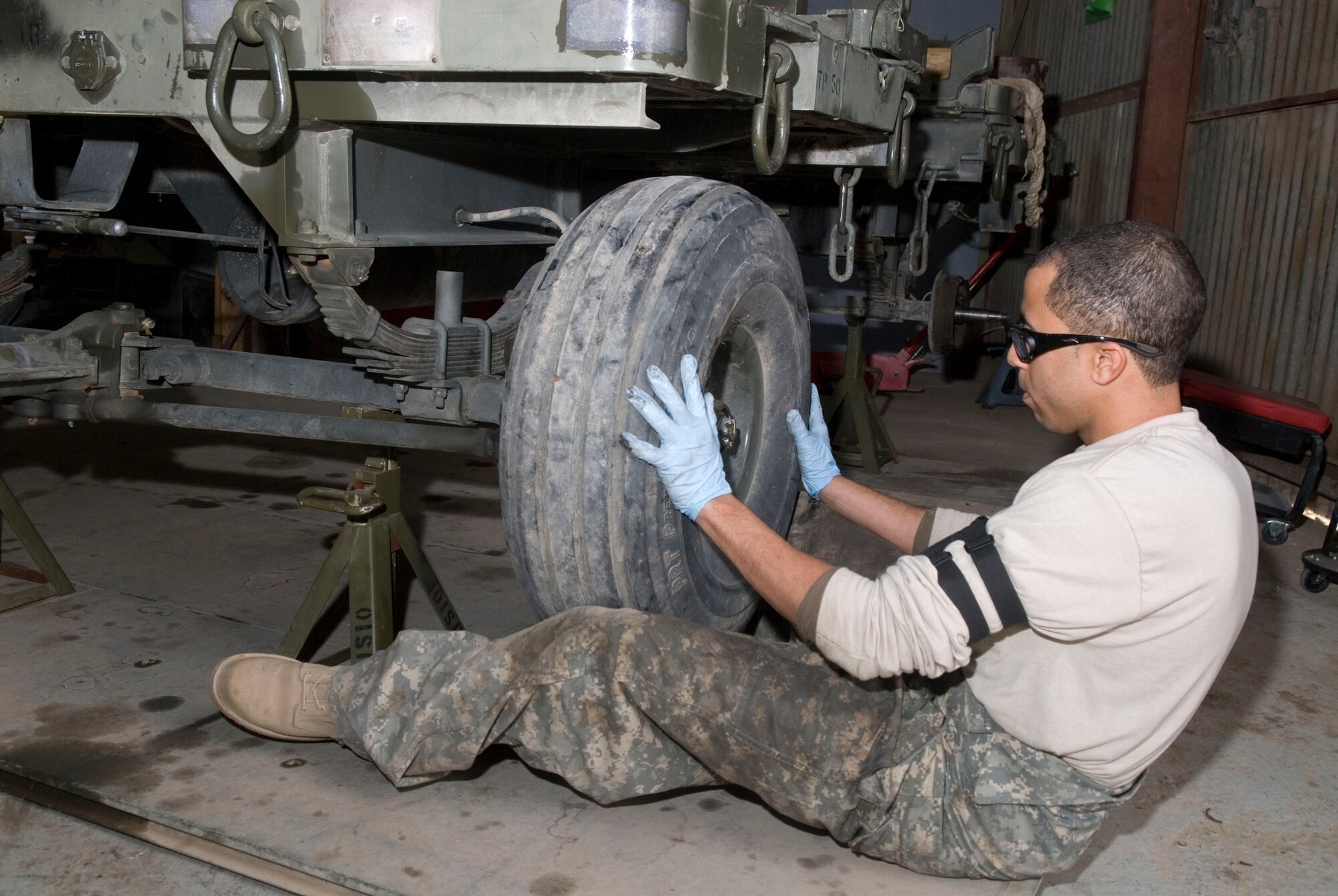 BALAD AIR BASE, Iraq -- Staff Sgt. Elvin Rose, a 332nd Expeditionary Maintenance Squadron munitions equipment maintainer, places a tire back onto a munitions trailer after reassembling the wheel drum during a 720-day inspection here, Dec. 19. The trailers receive inspections every 90, 180, 365, and 720 days, to ensure that they are serviceable. Sergeant Rose is deployed from Spangdahlem Air Base, Germany. (U.S. Air Force photo/Staff Sgt. Joshua Garcia)