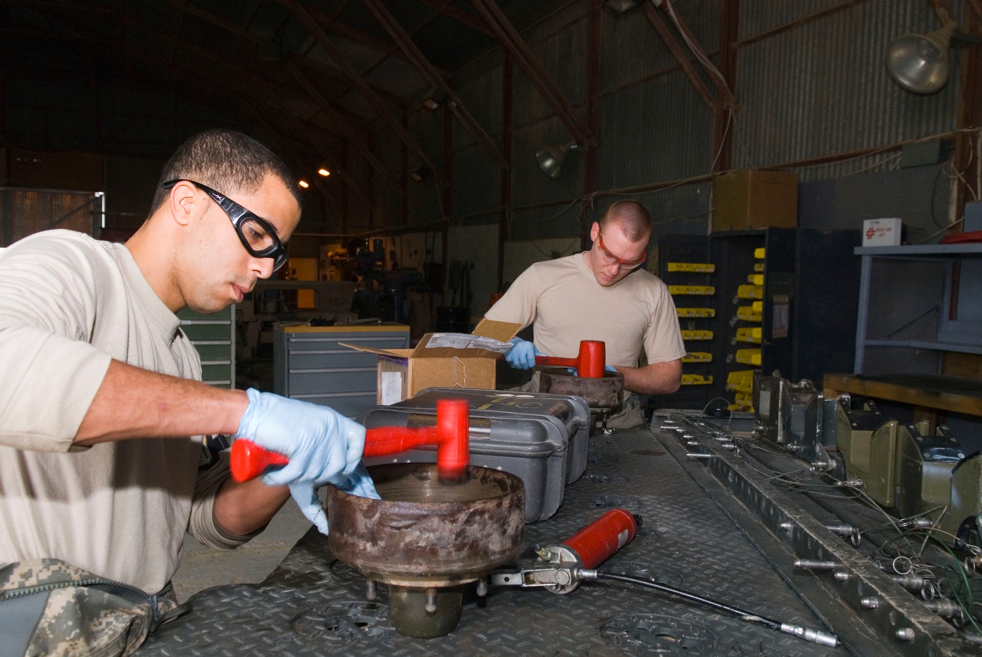 BALAD AIR BASE, Iraq -- Staff Sgt. Elvin Rose and Airman 1st Class Justin Porter, both 332nd Expeditionary Maintenance Squadron munitions equipment maintainers, secure bearing seals onto the brake drums for a munitions trailer during a 720-day inspection here, Dec. 19. Munitions equipment undergoes several types of inspections depending on how long the item has been used. Sergeant Rose and Airman Porter are deployed from Spangdahlem Air Base, Germany (U.S. Air Force photo/Staff Sgt. Joshua Garcia)