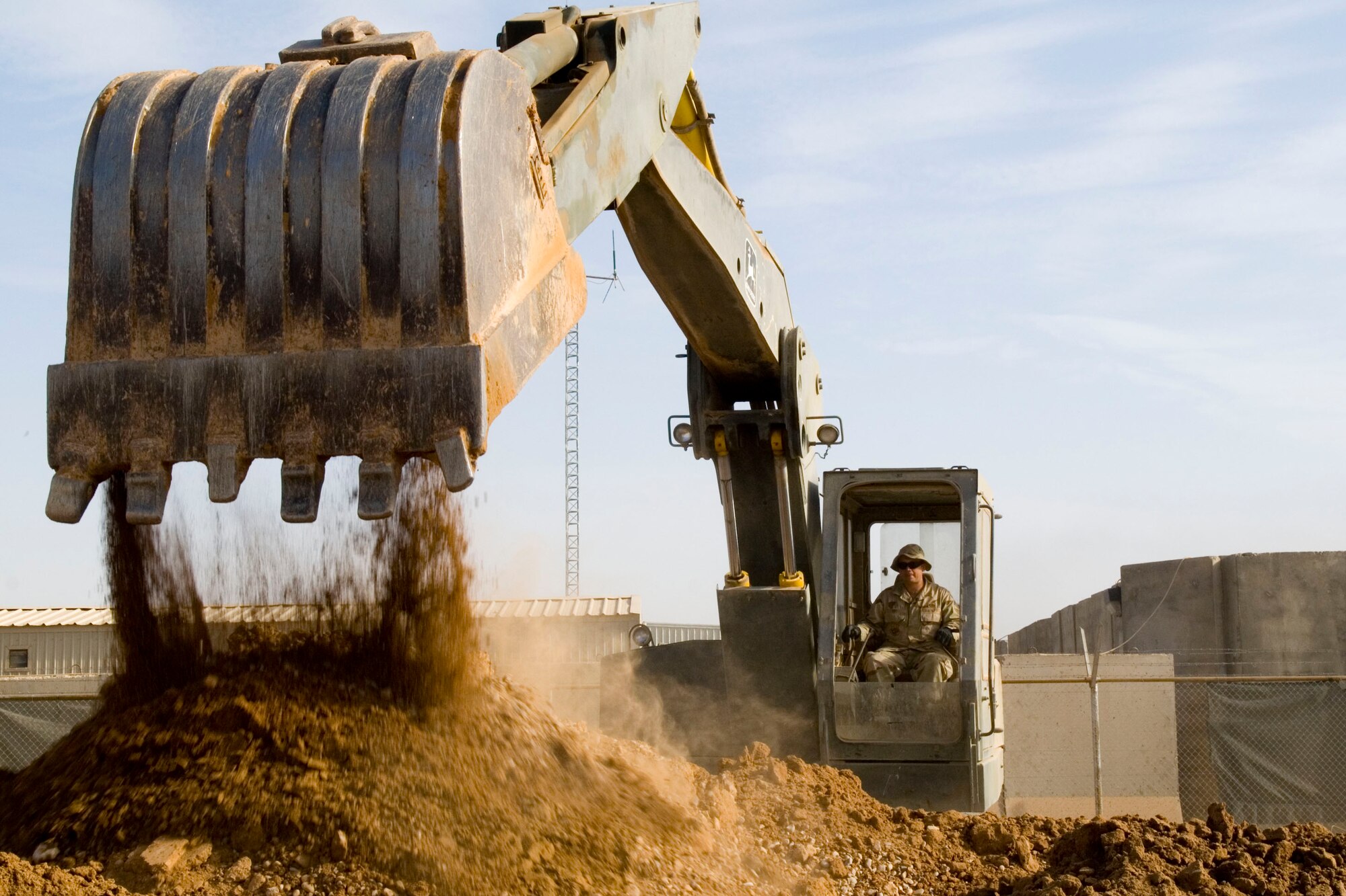BALAD AIR BASE, Iraq -- Staff Sgt. William Huff, a 332nd Expeditionary Civil Engineer Squadron heavy equipment operator, unloads dirt during a dig here, Dec. 18. The dig is being performed to locate the main sewer line which will be connected to living quarters here. Sergeant Huff is deployed from Spangdahlem Air Base, Germany. (U.S. Air Force photo/Staff Sgt. Joshua Garcia)