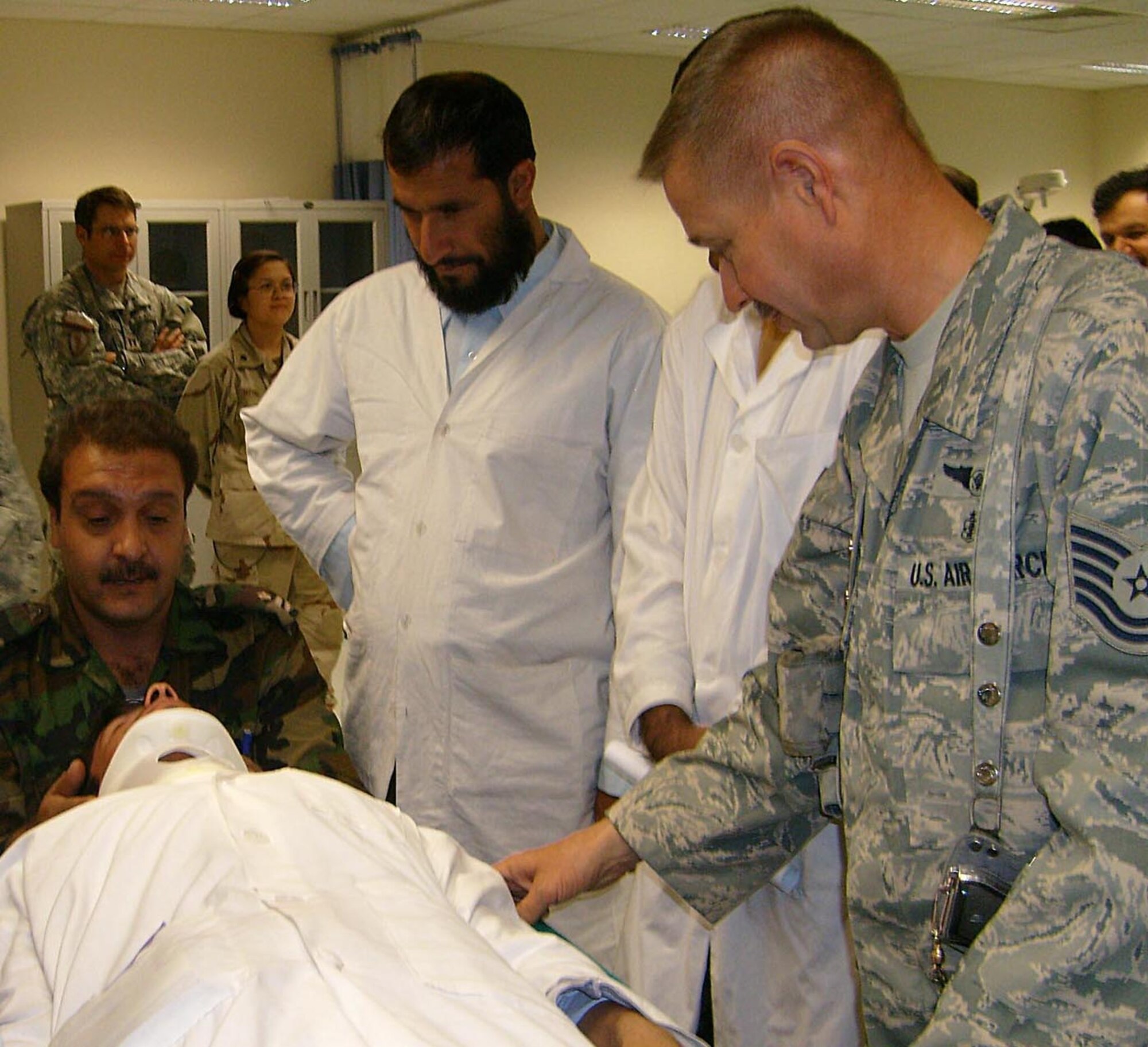 FOWARD OPERATING BASE HERO, Afghanistan -- Tech. Sgt. Edward Weaver, a medic deployed from Travis Air Force Base, Calif., instructs Afghan National Army medical personnel on spinal immobilization techniques at the newly-opened Kandahar ANA Regional Hospital in Afghanistan. The medical mentoring team arrived to find the construction 500 days behind schedule and immediately took on the task of supplying the hospital and getting it opened before continuing their mission of mentoring ANA medical personnel. (U.S. Air Force photo by Col. (Dr.) Thomas Seay)