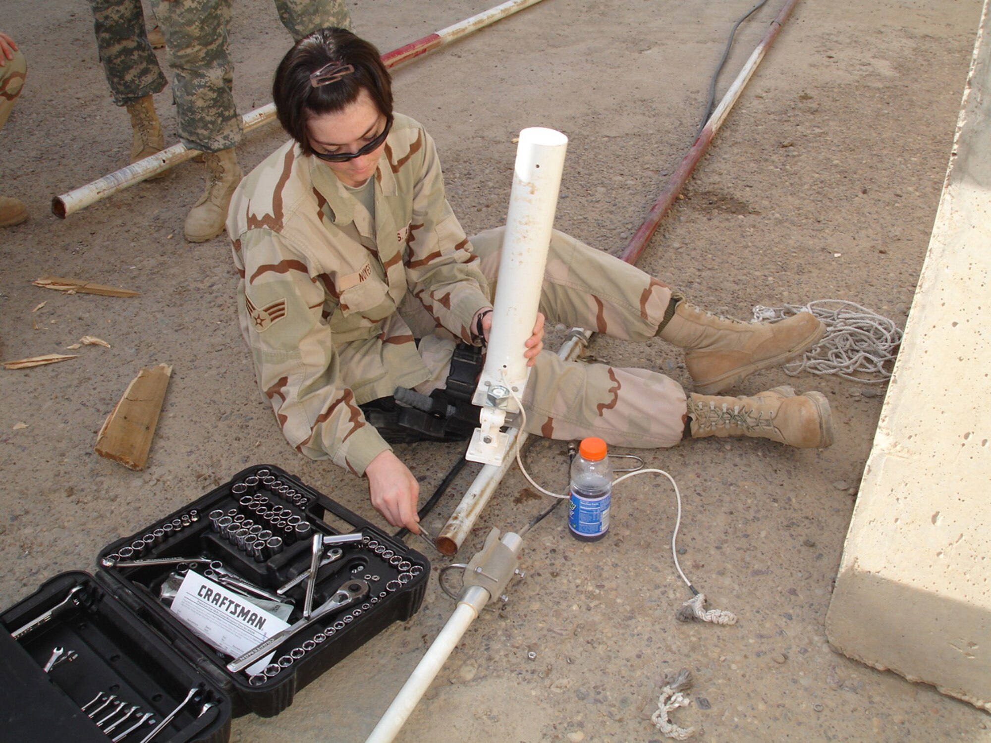 Senior Airman Jennifer Noyes, 1st Air and Space Communications Squadron, helps to construct a base and stand for a new 30-foot antenna. Airman Noyes was awarded the Defense Meritorious Service Medal for her accomplishments during a 365-day deployment to Baghdad. (Courtesy photo)