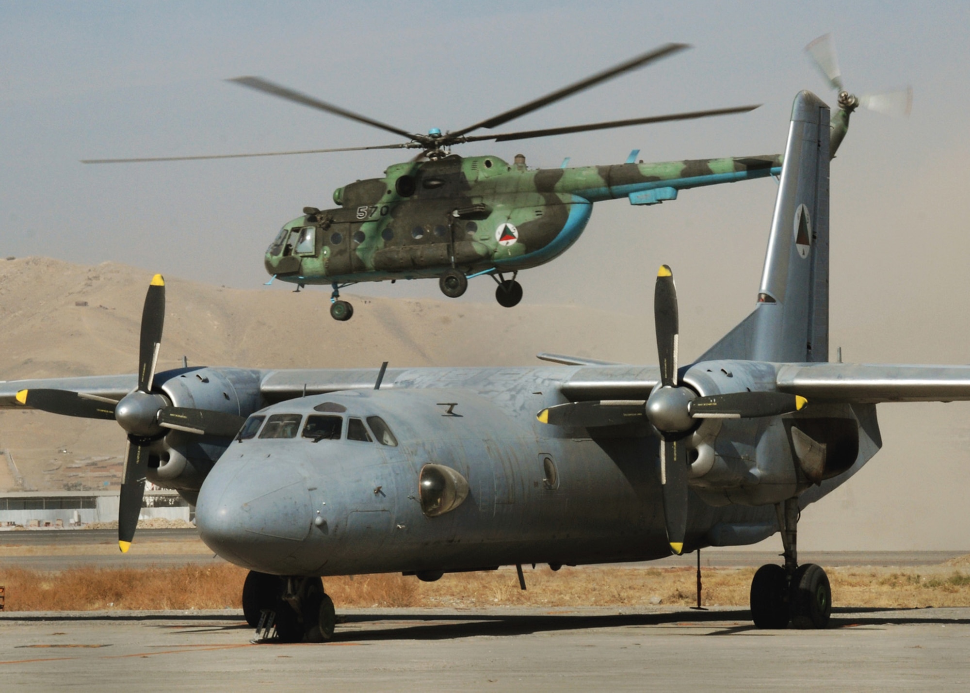 KABUL, Afghanistan - An Afghan National Army Air Corps MI-17 takes off past an AN-26 at the Kabul Air Base. (U.S. Navy Photo by Petty Officer First Class David M. Votroubek) 