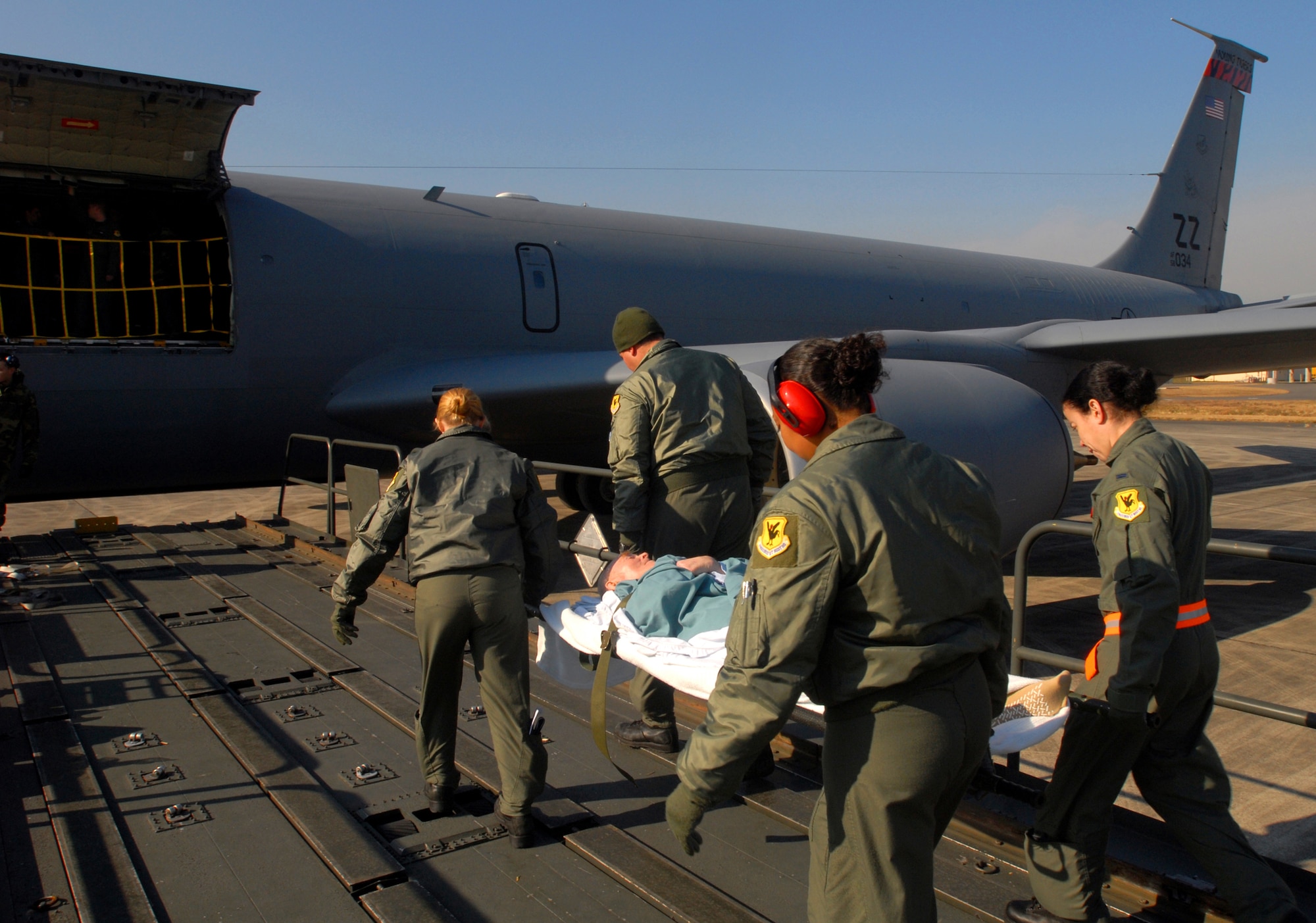 Airmen from the 18th Aeromedical Evacuation Squadron carry a patient from Yokota Air Base, Japan, onto a KC-135 Stratotanker bound for Kadena Air Base, Japan, Dec. 18. The patient will stay at the Camp Lester Naval Hospital for the night to receive critical care before being transported to Travis Air Force Base, Calif., for further treatment. The 18th AES travels throughout the Pacific picking up critical patients and transporting them to hospitals that can meet their needs. 
(U.S. Air Force photo/Staff Sgt. Chrissy FitzGerald)