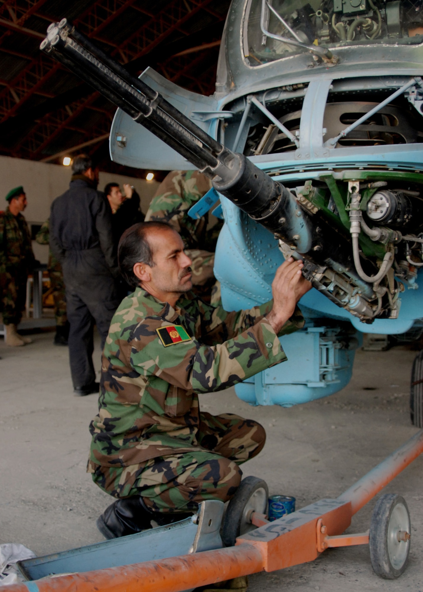 KABUL Afghanistan - A mechanic from the Afghan National Army Air Corps performs maintenance on a weapons system of a MI-35E helicopter in a hanger at the Kabul Air Base. Mechanics managed to keep these guns fully functional for fourteen years when ammunition was unavailable, even through the years when the Taliban ruled Afghanistan. (U.S. Navy Photo by Petty Officer First Class David M. Votroubek) 