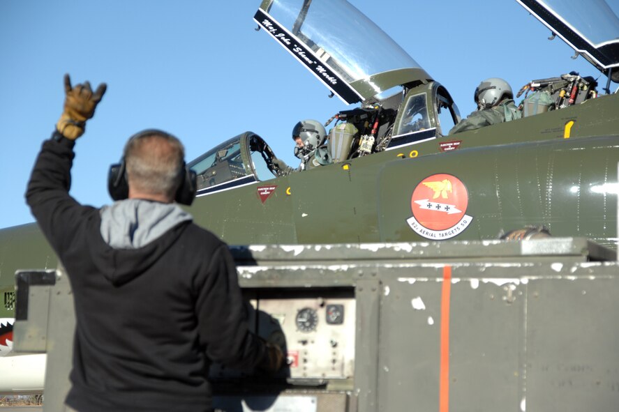 As Brig. Gen. David Goldfein, 49th Fighter Wing commander, and Maj. John Markle, Detachment 1, 82nd Aerial Targets Squadron duty officer, prepare for flight in a F-4 Phantom, Art Fisher, Lockheed Martin Services Incorporated maintainer, signals 'air on two' Dec. 20, 2007, at Holloman Air Force Base, N.M. 'Air on two' is the signal given once the starter air has been turned on for the number 2 engine. (U.S. Air Force photo/Airman 1st Class Jamal D. Sutter)