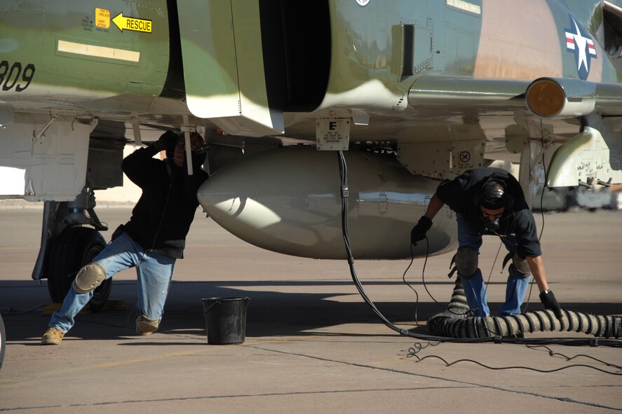 Art Fisher removes air from the hydrolic flight system of a F-4 Phantom and Bobby Aguilera clears away the -60 air hose Dec. 20, 2007, at Holloman Air Force Base, N.M. Fisher and Augilera, Lockheed Martin Services Incorporated, were the maintainers for Brig. Gen. David Goldfein's first flight in the Phantom. (U.S. Air Force photo/Airman 1st Class Jamal D. Sutter)