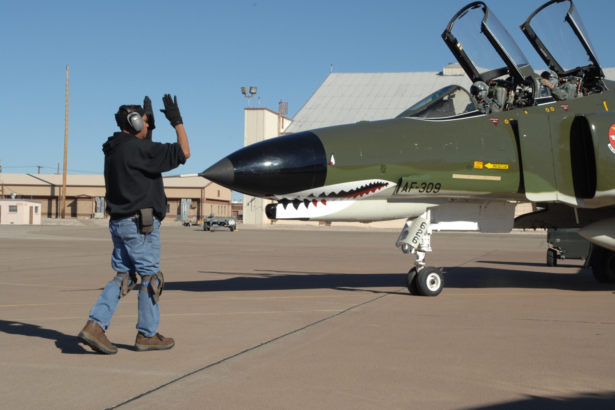 Bobby Aguilera, Lockheed Martin Services Incorporated, marshalls the aircraft before flight in a F-4 Phantom by Brig. Gen. David Goldfein, 49th Fighter Wing commander, Dec. 20, 2007, at Holloman Air Force Base, N.M. This was General Goldfein's first flight in the Phantom. (U.S. Air Force photo/Airman 1st Class Jamal D. Sutter)