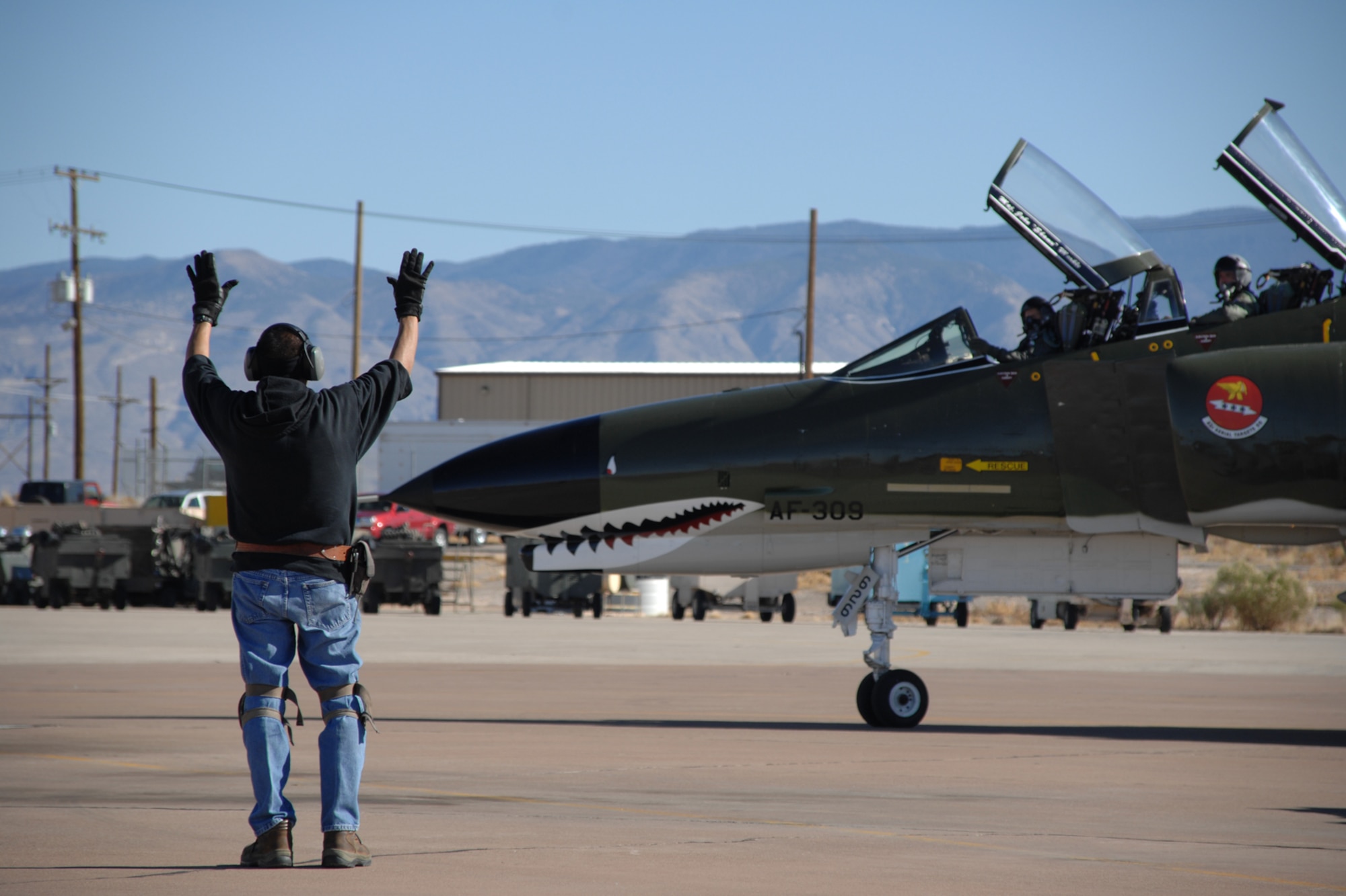 Bobby Aguilera, Lockheed Martin Services Incorporated, marshalls the aircraft after a succesful flight in a F-4 Phantom by Brig. Gen. David Goldfein, 49th Fighter Wing commander, Dec. 20, 2007, at Holloman Air Force Base, N.M. This was General Goldfein's first flight in the Phantom. (U.S. Air Force photo/Airman 1st Class Jamal D. Sutter)