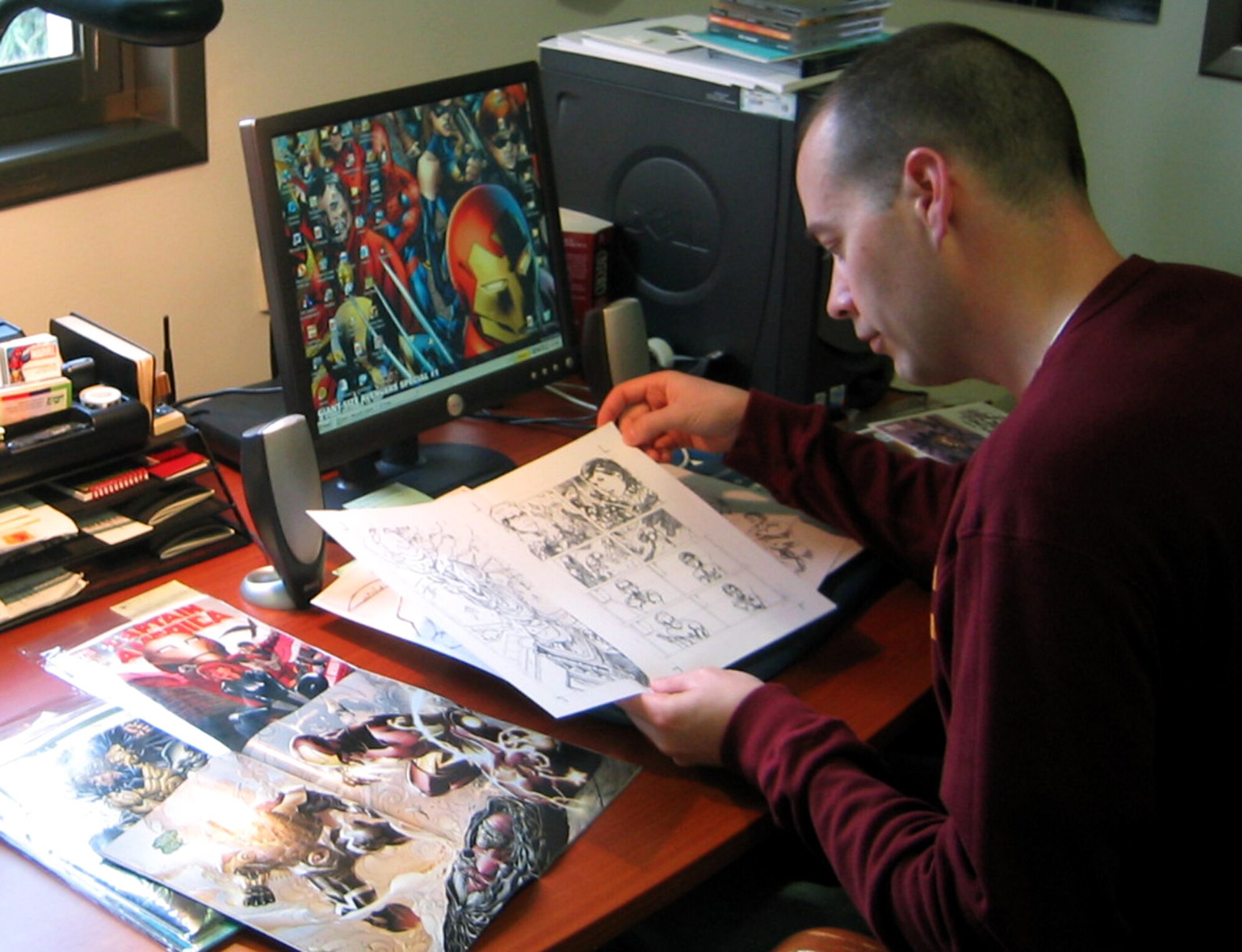 Major Matt Yocum reviews artwork for Marvel Comics' 'Giant-Size Avengers Special #1,' which will feature a story he wrote. The major, the assistant air attache at the U.S. Embassy in Tel Aviv, Israel, fell in love with comics at age 10 and said he never dreamed he'd one day be writing stories about Spider-Man and other superheroes. The issue with Major Yocum's story will be released Dec. 26. (Courtesy photo/Ann Marie Yocum)