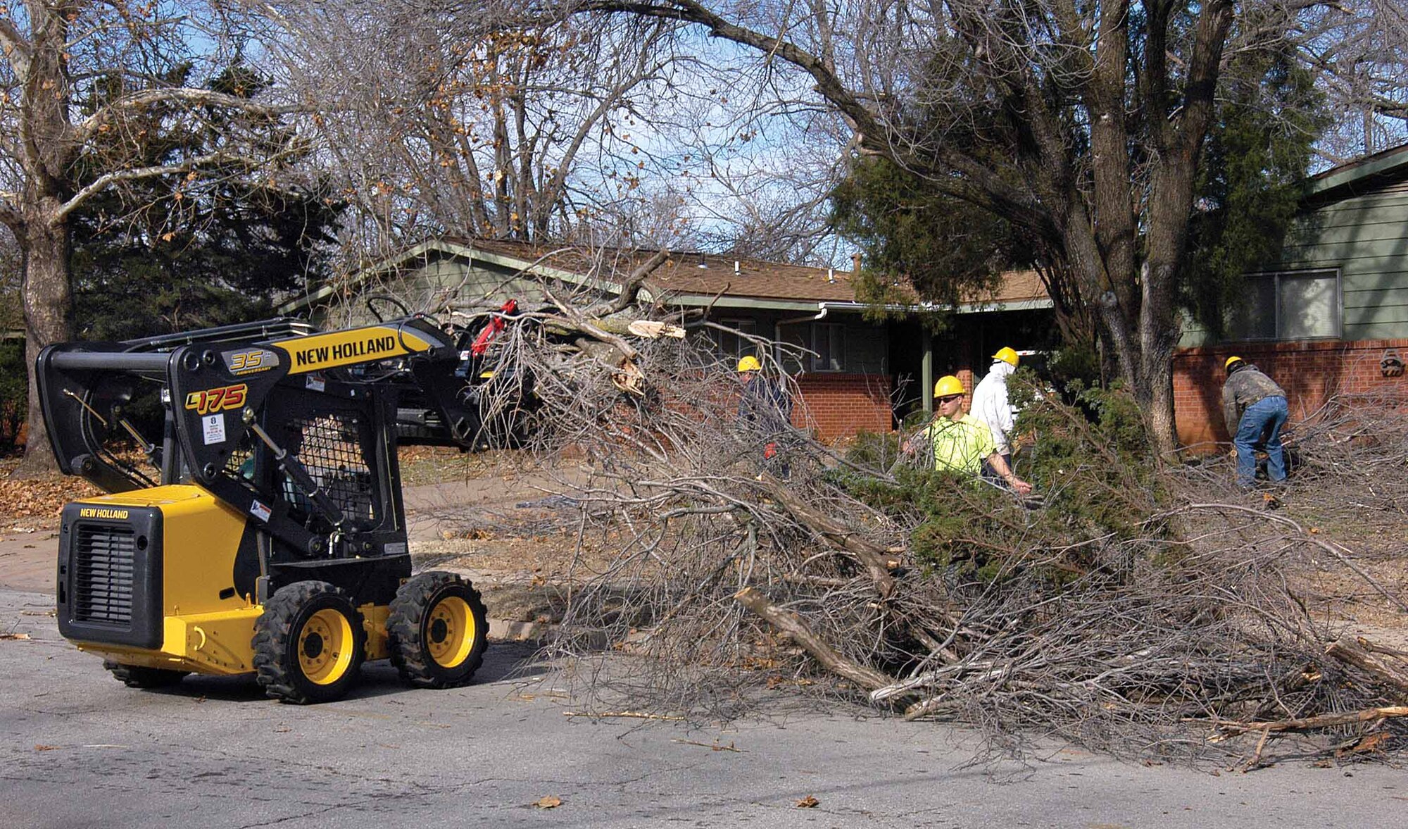 A crew from Fryars Lawn Care and Landscaping moves down Doolittle in base housing this week, clearing yards of tree limbs.  Owner John Fryar says Tinker was hit “pretty hard” and says after the initial clearing, crews will focus on pruning trees, removing broken branches still in the trees.  Other companies and crews are working across base to clean up after the ice storm. 