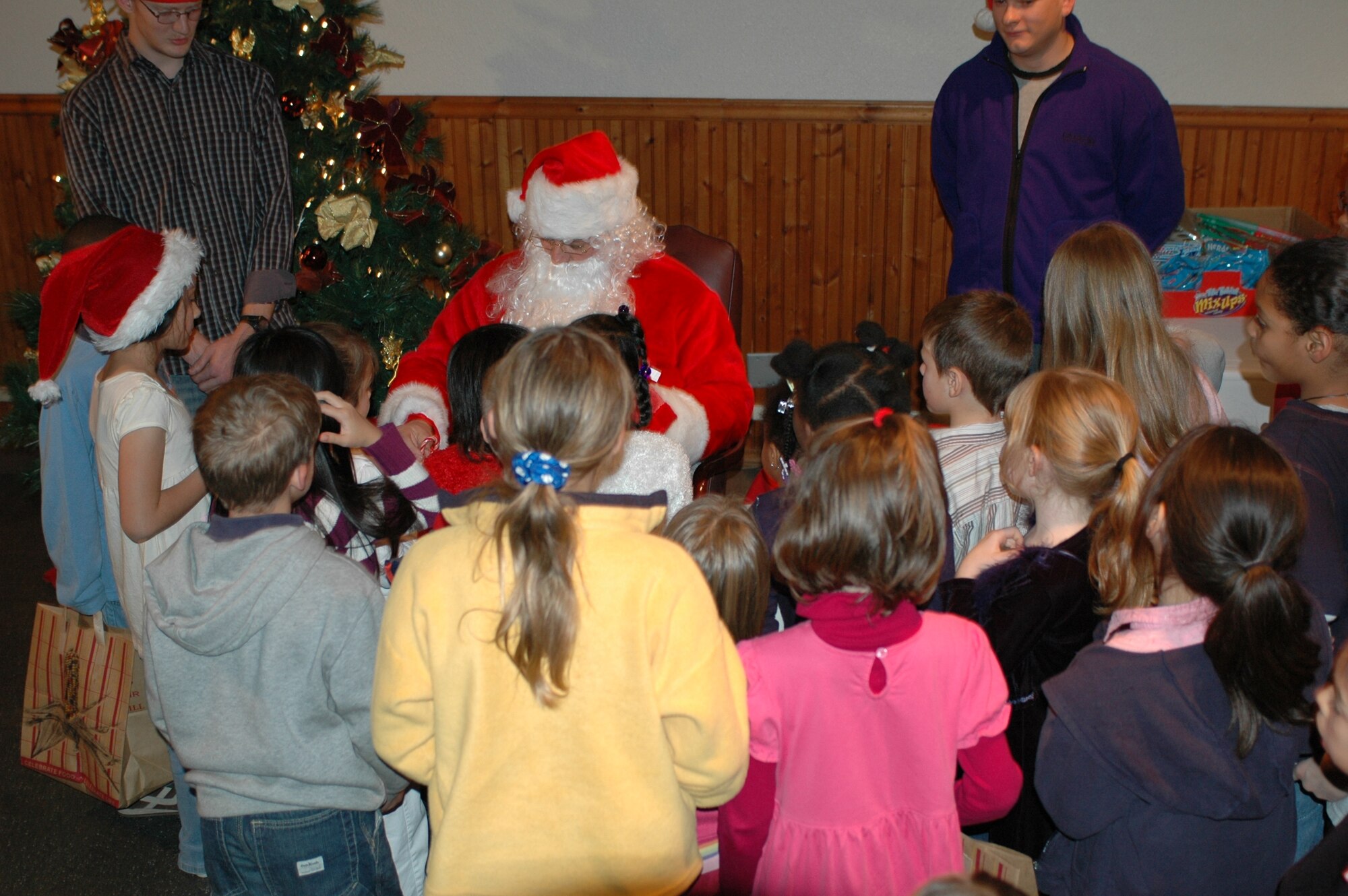 Santa Claus hands out gifts to children at the Deployed Spouses Dinner Dec. 18 at the Travis Conference Center. The event allows the spouses and children of deployed Travis members to socialize with other families while learning about availanle base and local resources. (U.S. Air Force photo/Senior Airman Shaun Emery)