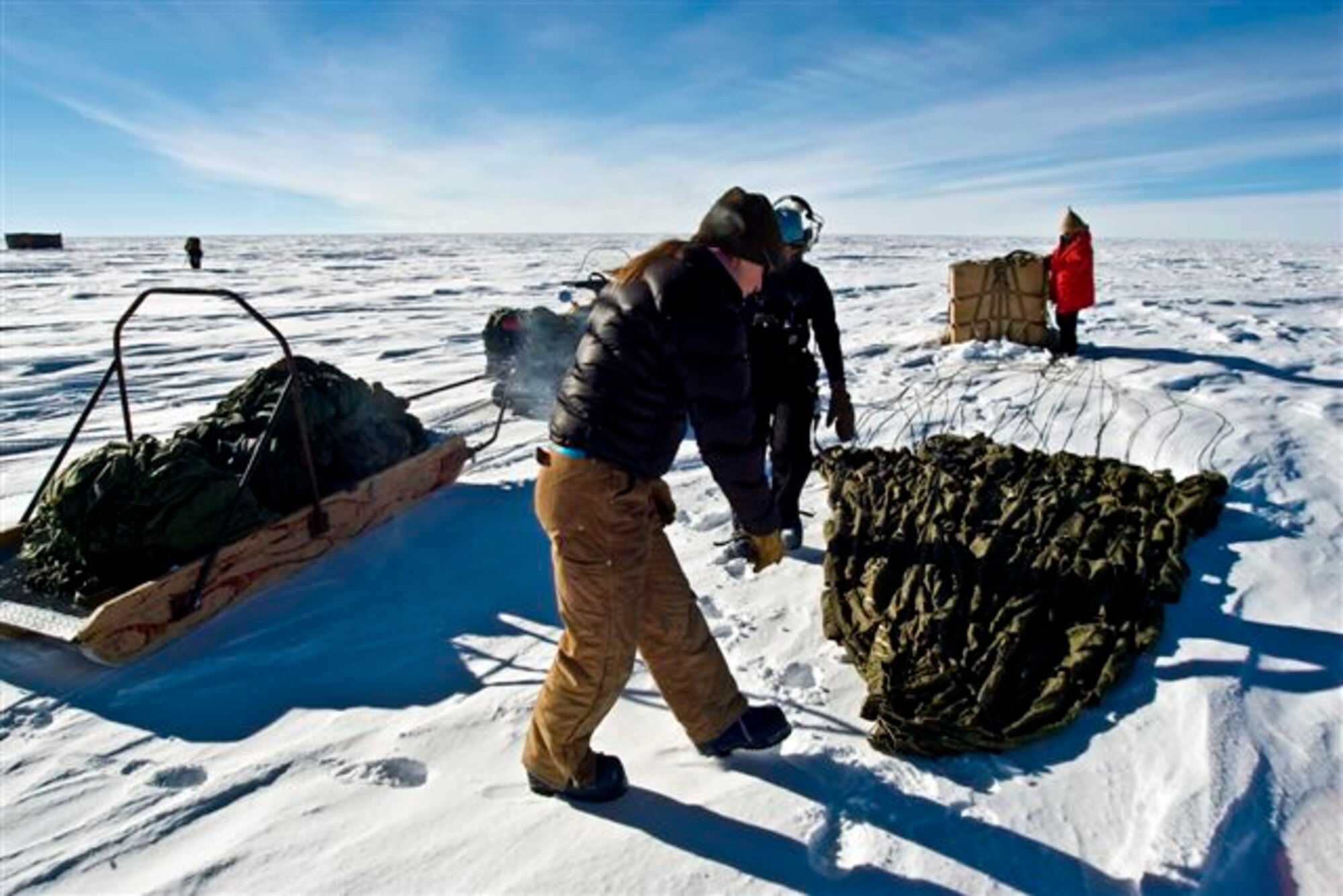 Containerized Delivery System bundles are recovered by a ground crew member at the South Pole. The bundles were airdropped by a McChord C-17 supporting Operation Deep Freeze.  The 13th Air Force-led Operation Deep Freeze is a unique joint and total force mission that has supported the National Science Foundation and U.S. Antarctic Program since 1955.  By validating the C-17 capability to complete airdrop missions at the Geographical South Pole, Joint Task Force-Support Forces Antarctica demonstrated its ability to provide mid-winter emergency re-supply and flexible support to the National Science Foundation and U.S. Antarctica Program. (U.S. Air Force photo)