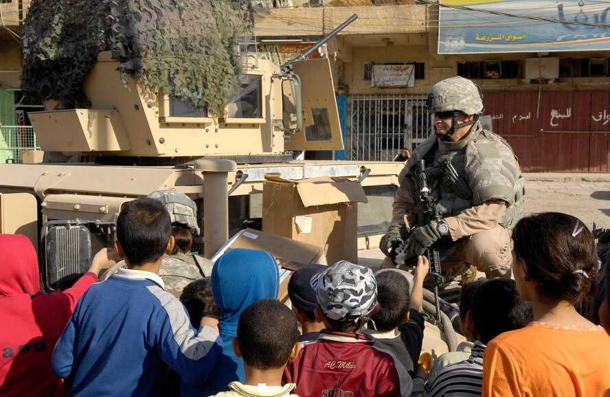 Tech. Sgt. Dustin Lord and Iraqi police officers hand out toys to local children Dec. 18 in Baghdad, Iraq, during a community relations outreach event. Security forces members from Det. 3 of the 732nd Expeditionary Security Forces Squadron, attached to the Army's 92nd Military Police Brigade, help train, mentor and coach the Iraqi police to help build a secure and independent Iraq. (U.S. Air Force photo/Staff Sgt. Brian Ferguson)