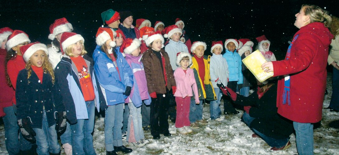 Leigh Thornley directs the Andrews Home Educators Choir in singing "Joy to the World" during their debut at the Annual Base Holiday Tree and Menorah lighting ceremony at Chapel 1, Dec. 5. Andrews families were also treated with food, refreshments and performances by the Andrews Gospel Youth Chorus and the U.S. Air Force "Airmen of Note" combination band. There was even a s pecial visit from Santa, Mrs. Claus and Santa's helper, via fire engine, driven by the 316th Civil Engineer Squadron firefighters. Mrs. Thornley is the wife of Ch. (Capt.) Andrew Thornley, Chapel 1 senior protestant chaplain. (US Air Force/Bobby Jones)