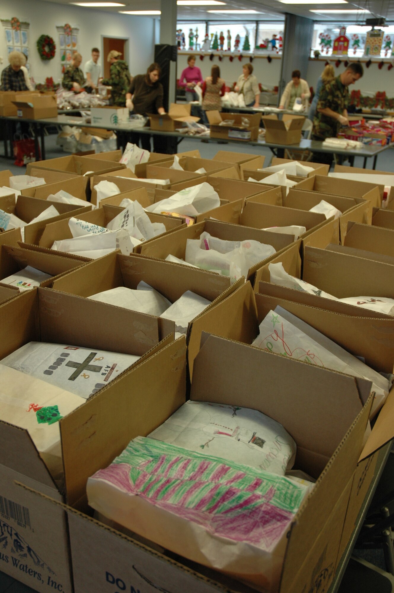 Volunteers from Hill Air Force Base gather together to bag cookies. More than 45 cases of cookie dough were donated by HC Brill and cooked by members from Hill. The cookies were made for Hill AFB dorm residents and employees working on Christmas Eve.