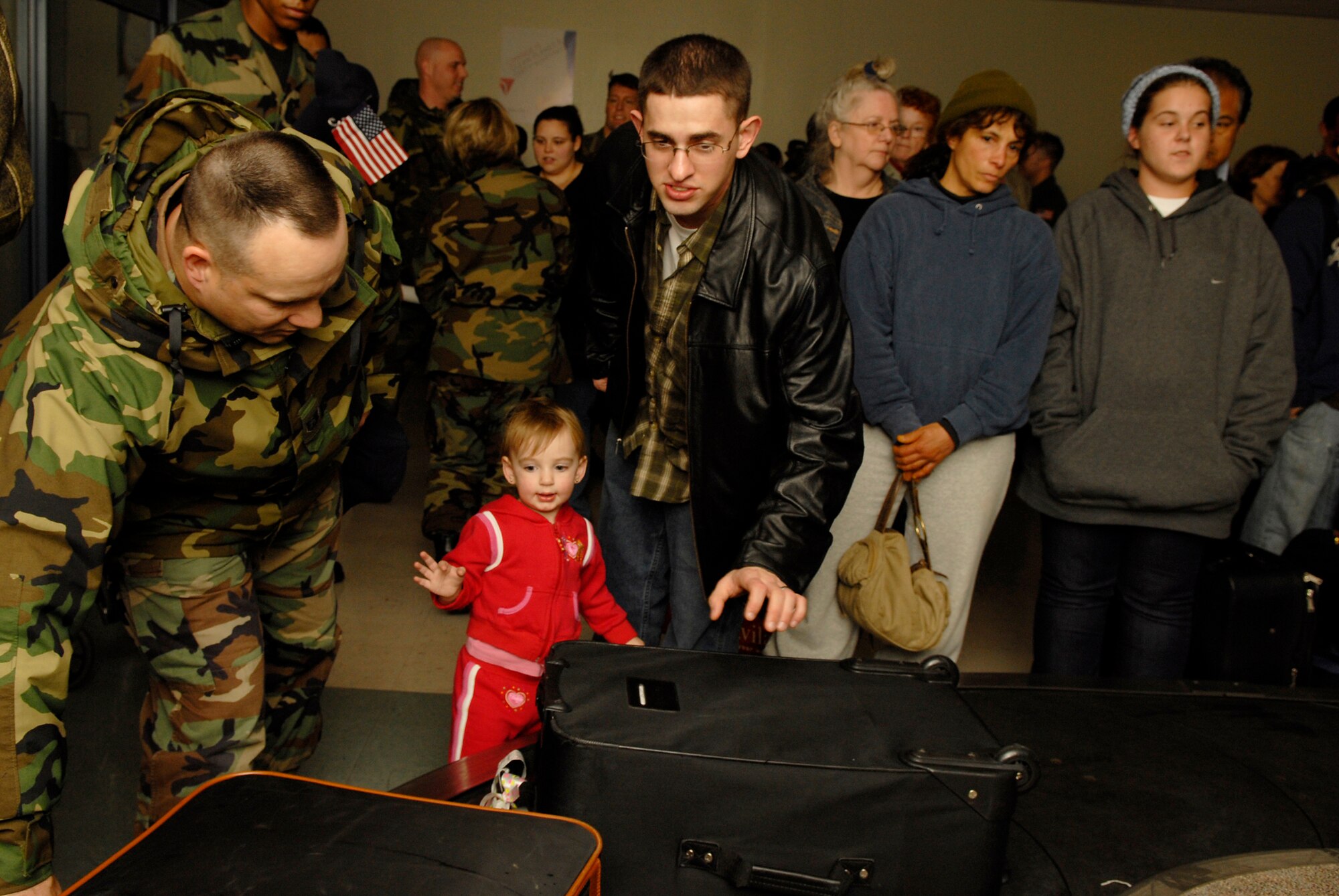 VANDENBERG AIR FORCE BASE, Calif. -- Tech. Sgt. Russell McBride helps Airman 1st Class Michael Brady claim his luggage upon his return home Dec. 18.  Airman Brady, who deployed to Iraq, was performing Combat Camera support for soldiers when he was wounded in the neck by enemy fire near Ad Diwaniyah, Iraq, Oct. 12.  Airman Brady was awarded the Purple Heart and the Iraqi Campaign Medal from Brig. Gen. Burt Field, the 332nd Air Expeditionary Wing commander, while still in Iraq.  Airman Brady was accompanied by his family and was met by a large group of friends and coworkers. (U.S. Air Force photo/Airman 1st Class Christian Thomas)

