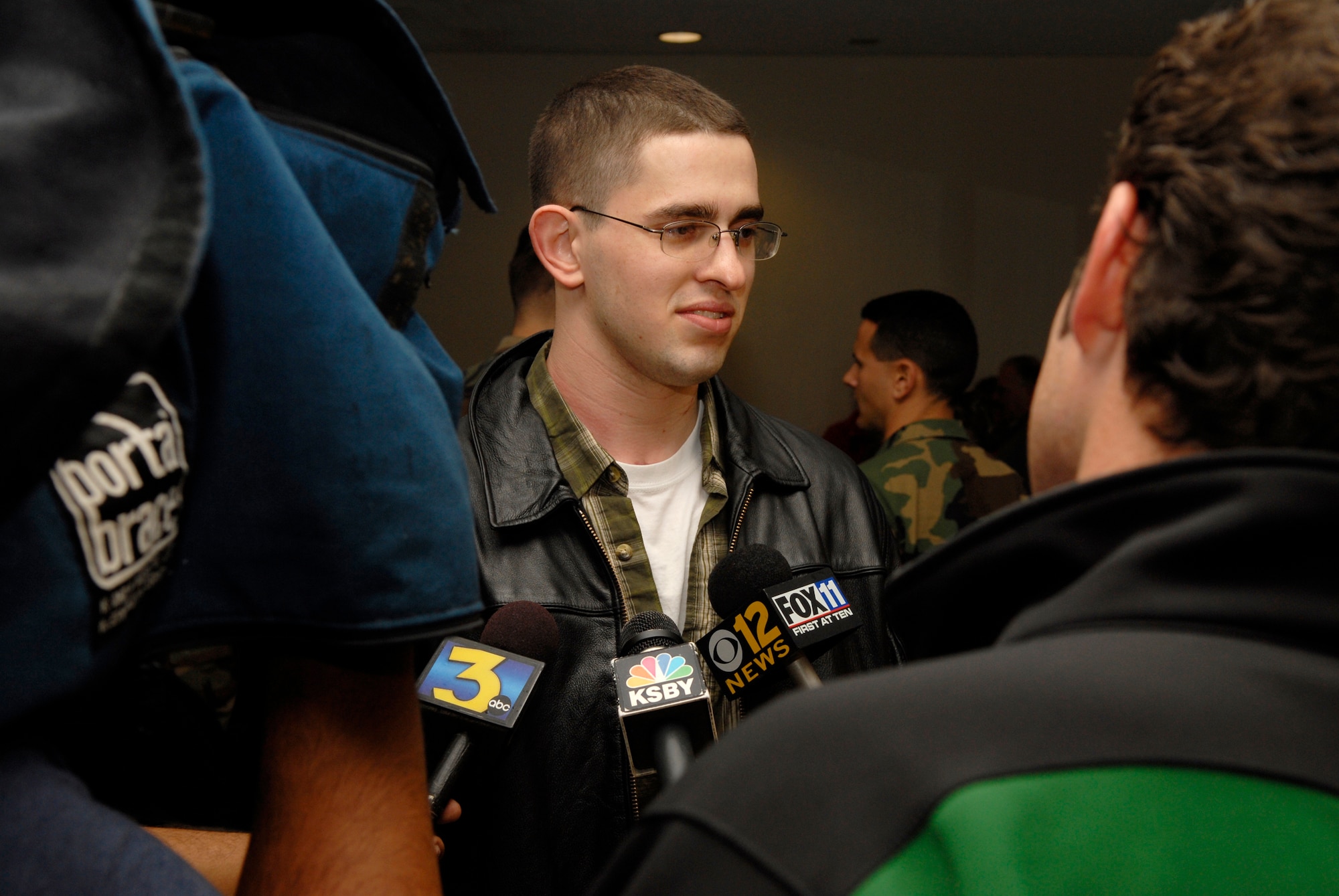 VANDENBERG AIR FORCE BASE, Calif. -- Airman 1st Class Michael Brady answers questions from local media upon his return home Dec. 18.  Airman Brady, who deployed to Iraq, was performing Combat Camera support for soldiers when he was wounded in the neck by enemy fire near Ad Diwaniyah, Iraq, Oct. 12.  Airman Brady was awarded the Purple Heart and the Iraqi Campaign Medal from Brig. Gen. Burt Field, the 332nd Air Expeditionary Wing commander, while still in Iraq.  Airman Brady was accompanied by his family and was met by a large group of friends and coworkers. (U.S. Air Force photo/Airman 1st Class Christian Thomas)

