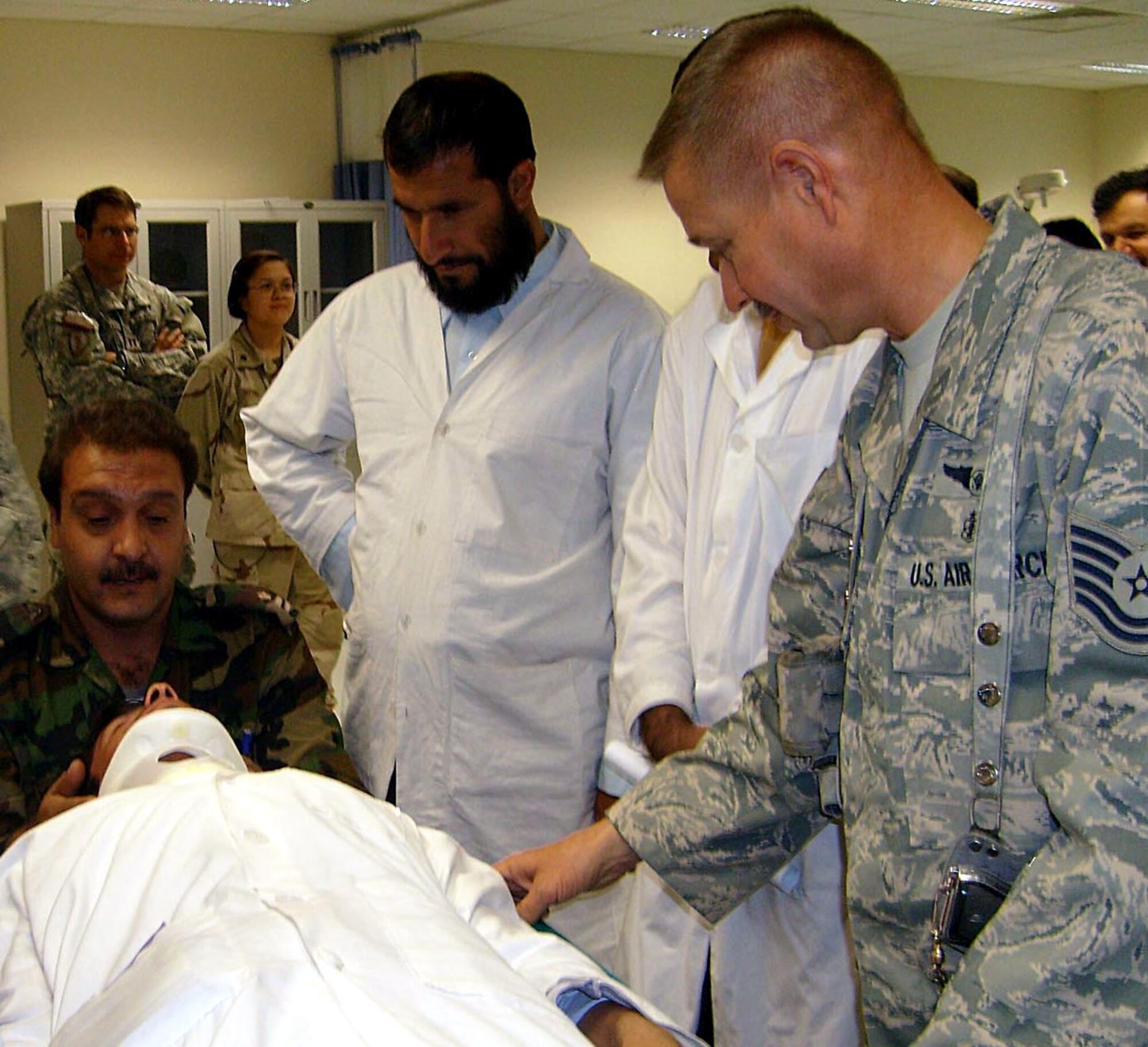 Tech. Sgt. Edward Weaver instructs Afghan national army medical personnel Dec. 19 on spinal immobilization techniques at the newly-opened Kandahar ANA Regional Hospital in Afghanistan. The medical mentoring team arrived to find the construction 500 days behind schedule and immediately took on the task helping to supply and open the hospital before carrying out their mission of mentoring ANA medical personnel. Sergeant Weaver is a medic deployed from Travis Air Force Base, Calif. (U.S. Air Force photo/Col. (Dr.) Thomas Seay)