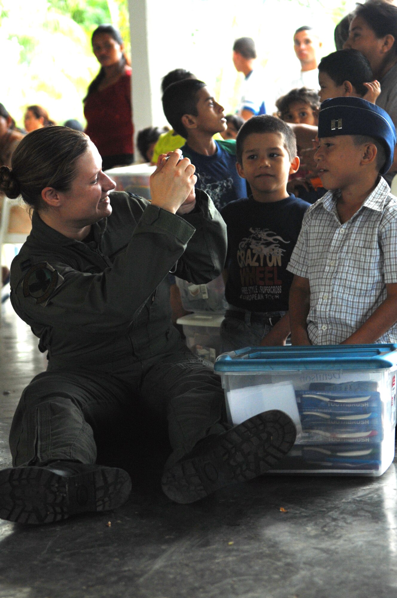 Capt. Heather Demis, 9th Special Operations Squadron, takes a photo of a Honduran orphan wearing her flightcap at Aldea Infantil S.O.S Orphanage in La Ceiba, Honduras during Operation Christmas Wish, Dec. 13. Captain Demis was part of a 16 person team that helped deliver more than 875 Christmas packages to five different Honduran orphanages. (U.S. Air Force photo/Senior Airman Ali Flisek)