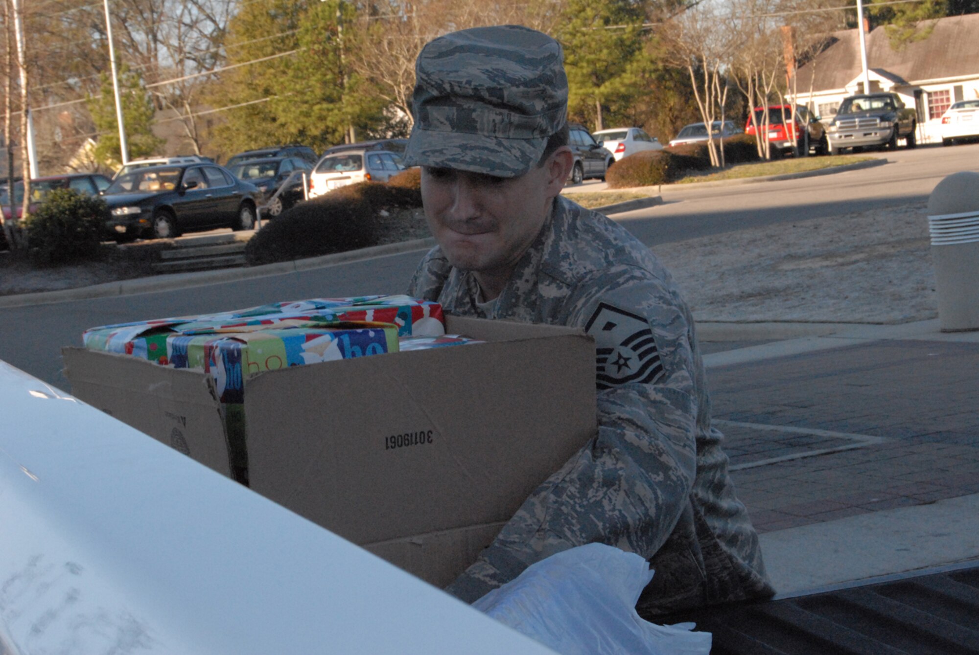 Master Sgt. Jerry Glover picks up a box of presents Dec. 18 to deliver to children in the local foster care system near Pope Air Force Base, N.C. Sergeant Glover is the 43rd Security Forces Squadron first sergeant. (U.S. Air Force photo/Airman Mindy Bloem)
